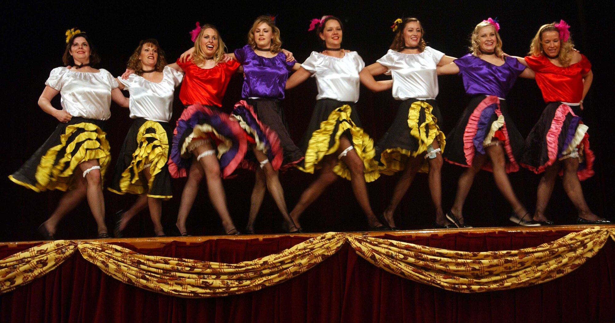 OSAN AIR BASE, Republic of Korea -- Members of the Osan Officers Spouses' Club perform a "Can Can" dance for the crowd at the Wild West Night Feb. 2 at the officers' club. More than 200 members of Team Osan took part in the Western-themed annual fundraiser, first started in 1980, and sponsored by the spouses' club. In addition to games of chance, participants could also bid with funny money in a silent auction for a variety of items. The proceeds from the event are returned to the community in the form of scholarships and sponsorship of base events. (U.S. Air Force photo/Tech. Sgt. Matt Summers)