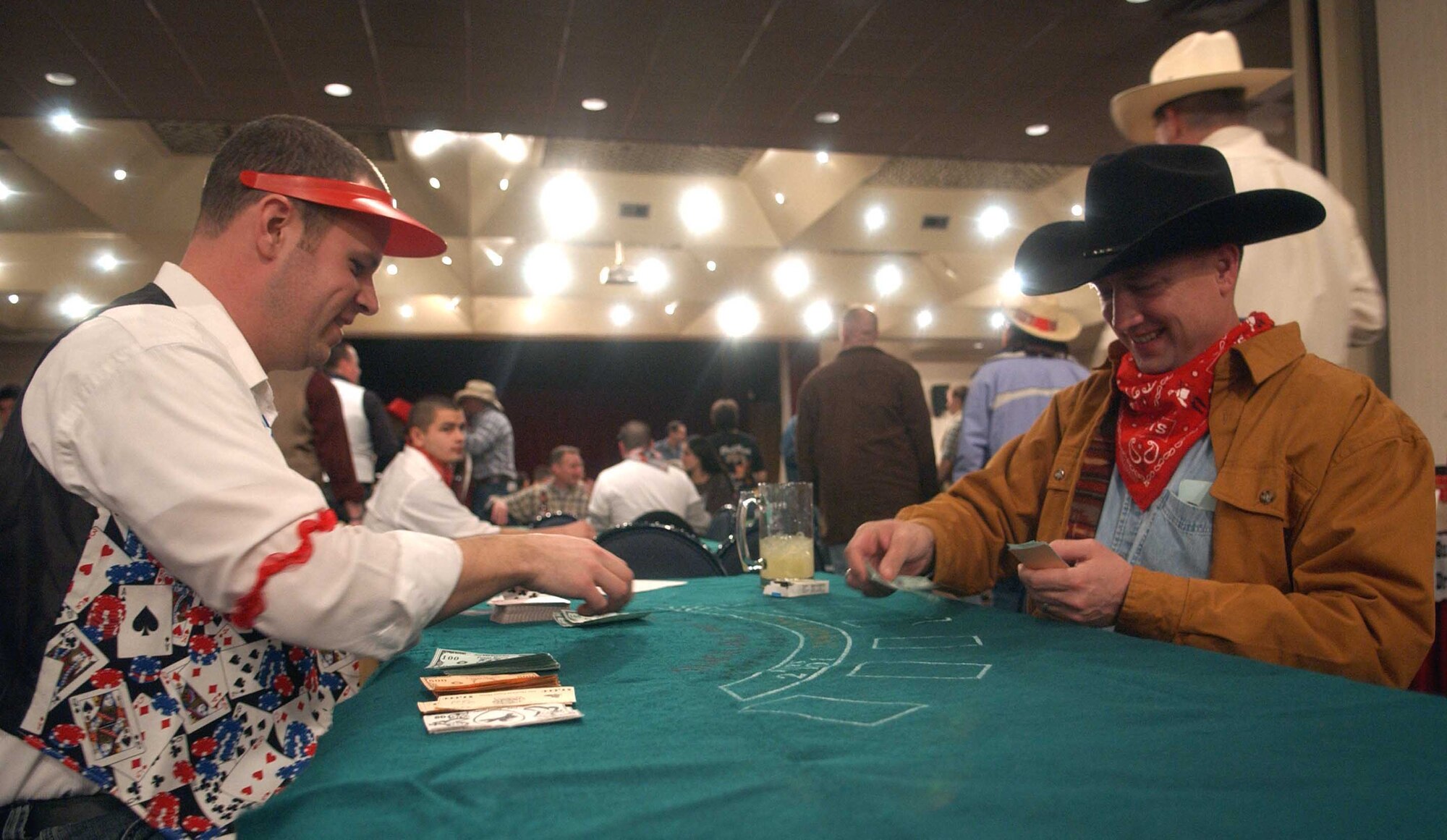 OSAN AIR BASE, Republic of Korea -- Col. Jon Norman, 51st Fighter Wing commander, (right), places a bet of funny money with Capt. John Ross, 51st FW Public Affairs and blackjack dealer, at the Wild West Night Feb. 2 at the officers' club. In addition to games of chance, participants could also bid with funny money in a silent auction for a variety of items. (U.S. Air Force photo/Tech. Sgt. Matt Summers)