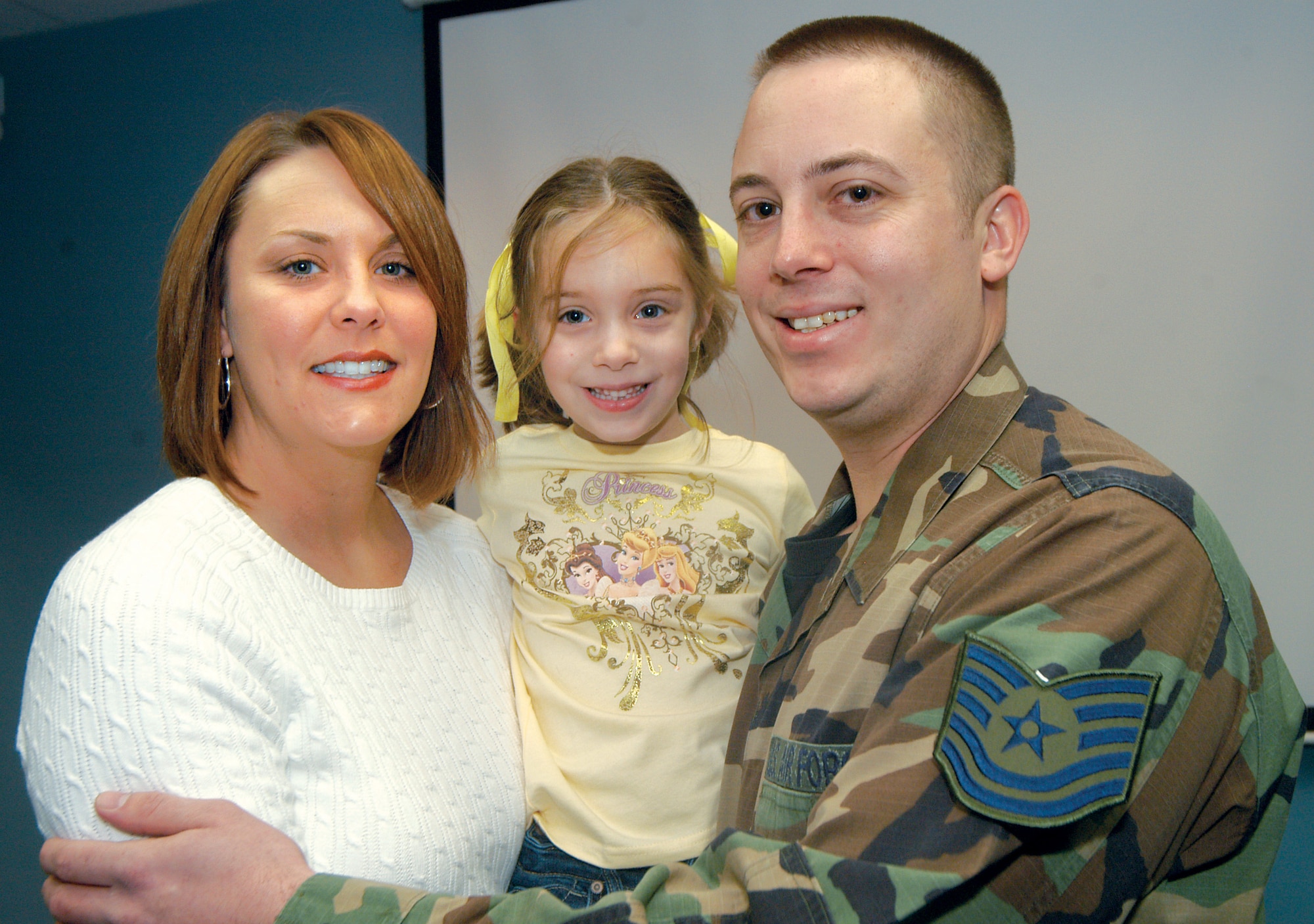 TSgt. John Besselman, his wife Shannon and daughter Alyssa, 5, are all smiles after he received a  Stripes for Exceptional Performance promotion Feb. 24.  U. S. Air Force photo by Sue Sapp                                 