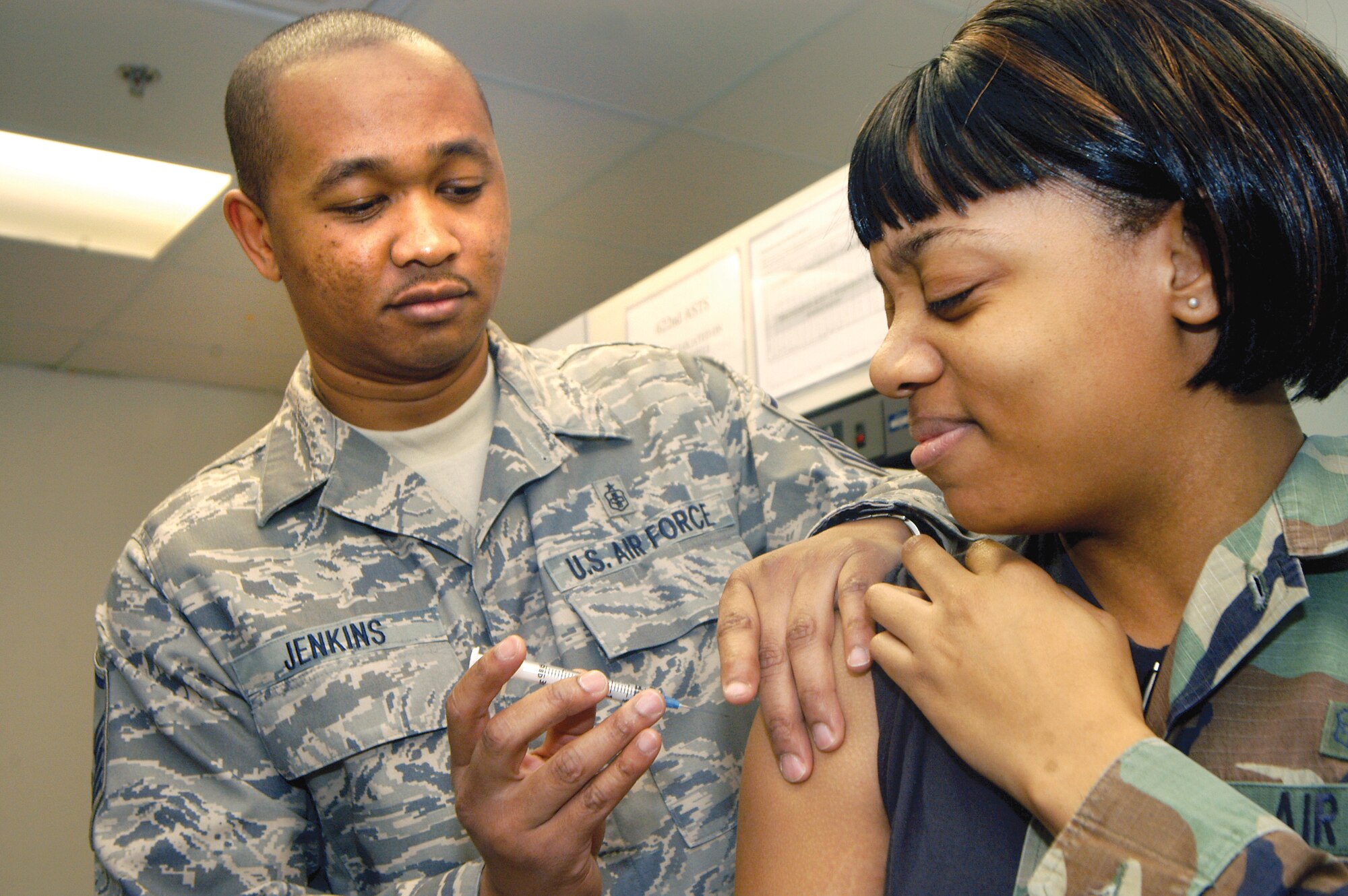 MSgt Jack Jenkins, allergy/immunization technician, gives SrA Samantha Bryant a shot at the clinic. U. S. Air Force photo by Sue Sapp 