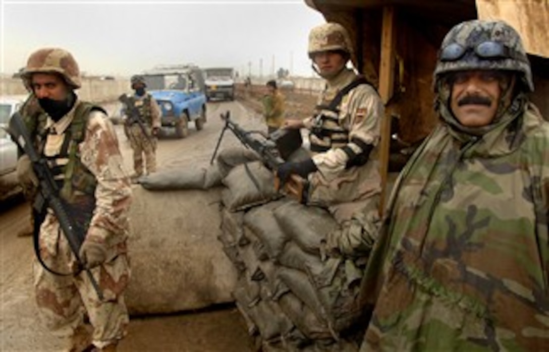 Iraqi army soldiers and an Iraqi policeman guard a checkpoint in Baghdad, Iraq, Jan 26, 2008. 