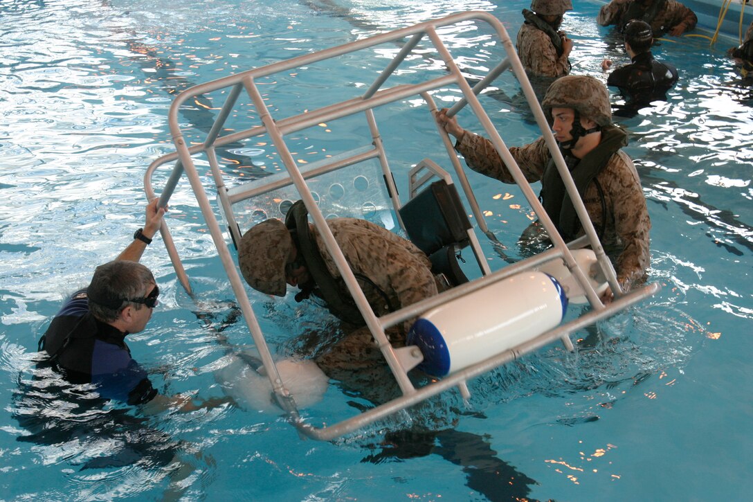 CAMP LEJEUNE, N.C. (Feb. 6, 2008) ? A Marine with the 26th MEU Command Element assumes the crash position before immersion while SWET Instructor Ron Welsh and Lance Cpl. Luis A. Benitez supervise.  Marines and Sailors of the 26th MEU participated in SWET aboard Camp Lejeune, N.C., Feb. 6-7, 2008. The exercise taught the Marines to escape a downed helicopter under water. (Official USMC photo by Gunnery Sgt. Clark Schindler) (Released)