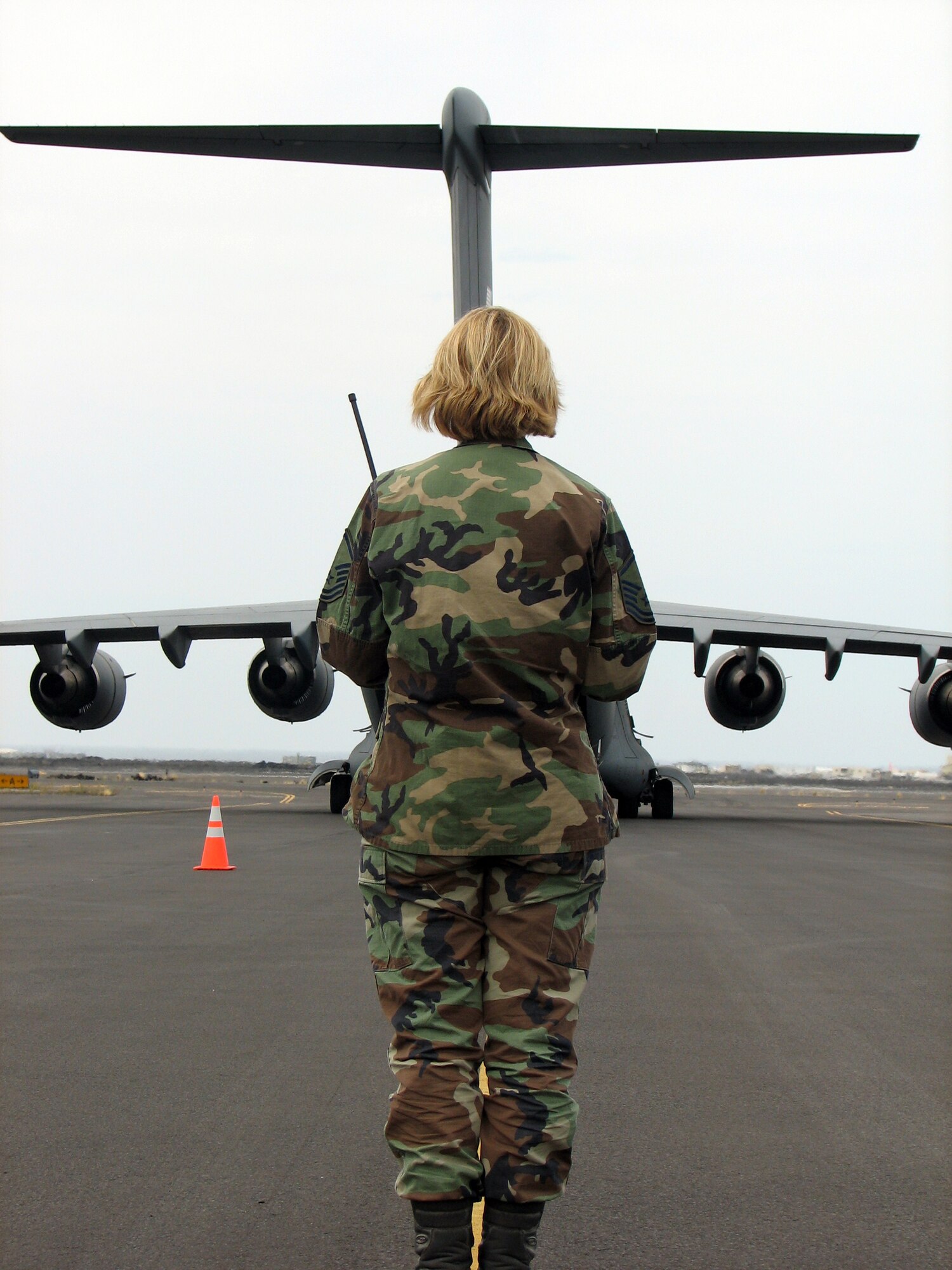 Master Sgt. Christina Bolle, an airfield manager with the 36th Contingency Response Group, Andersen Air Force Base, Guam, greets an arriving C-17 Globemaster III at the Kona International Airport, Kona, Hawaii, during an aeromedical transport mission Feb. 2.  The 36th CRG deployed more than 85 Airmen to Kona who set-up and provided base operational support including security, airfield management, water and power production, food services and a tent city capable of housing 300 during exercise Pacific Lifeline.  (U.S. Air Force Photo by Senior Master Sgt. Charles Ramey) 