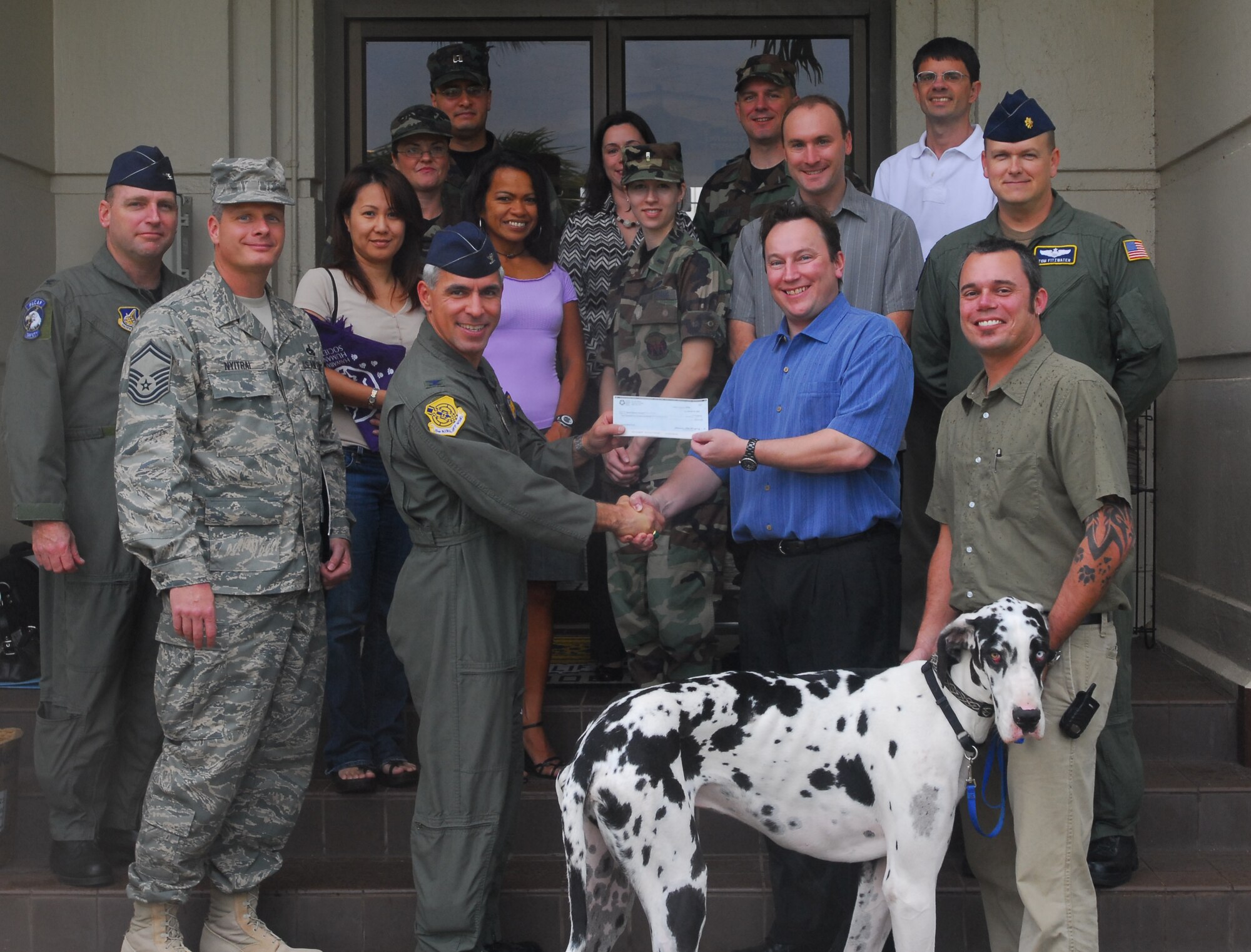 Col. JJ Torres, 15th Airlift Wing commander, presents a $2,500 check to Keith Kraughto, Hawaiian Humane Society Director of Development. To raise this money, Members of the Animal Relief Fund collected Hawaii 5-cent returnables and donated all proceeds to the Humane Society. The group was established to assist those programs dedicated to provide assistance to animals.  Front Row: Senior Master Sgt. Dave Nyitrai, Animal Relief Fund Founder; Col. JJ Torres, 15th Airlift Wing commander; Keith Kraughto and Rigo Neira (and his dog, Cash) from the Humane Society Middle Row: Col. John Kreger, Pacific Air Forces; Mayumi Nyitrai; Daria Bautista, PACAF;1st Lt Diana Wolczek-Evans,56th Air Communications Squadron;  Richard Granson, PACAF and Maj. Thomas Fitzwater, PACAF. Top Row: Capt. Leonce Brooks, PACAF; Master Sgt. Tonda Fryzlewicz,PACAF; Tammy Buker, PACAF; Master Sgt.David Gurley, PACAF and Lloyd Puckett, PACAF.
Photo by Staff Sgt. Erin Smith
