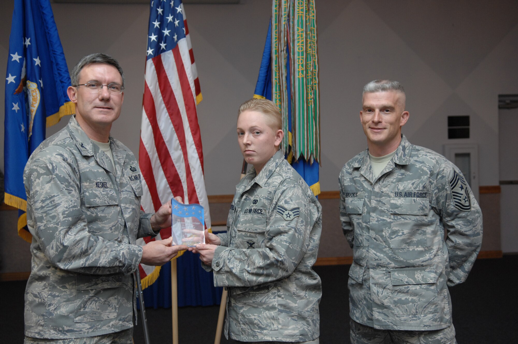 NELLIS AIR FORCE BASE, Nev.—Senior Airman Lindsey Whitfield, 99th Security Support Squadron assistant personnel reliability program noncommissioned officer in charge (center), receives the inaugural Air Force-level Elizabeth N. Jacobson Award for Expeditionary Excellence from Col. Kenneth Keskel, 99th Air Base Wing vice commander, during an awards ceremony here Jan. 31 as 99th ABW Command Chief Master Sgt. Robert Brooks (right) looks on. (U.S. Air Force photo by Senior Airman Larry E. Reid Jr.)