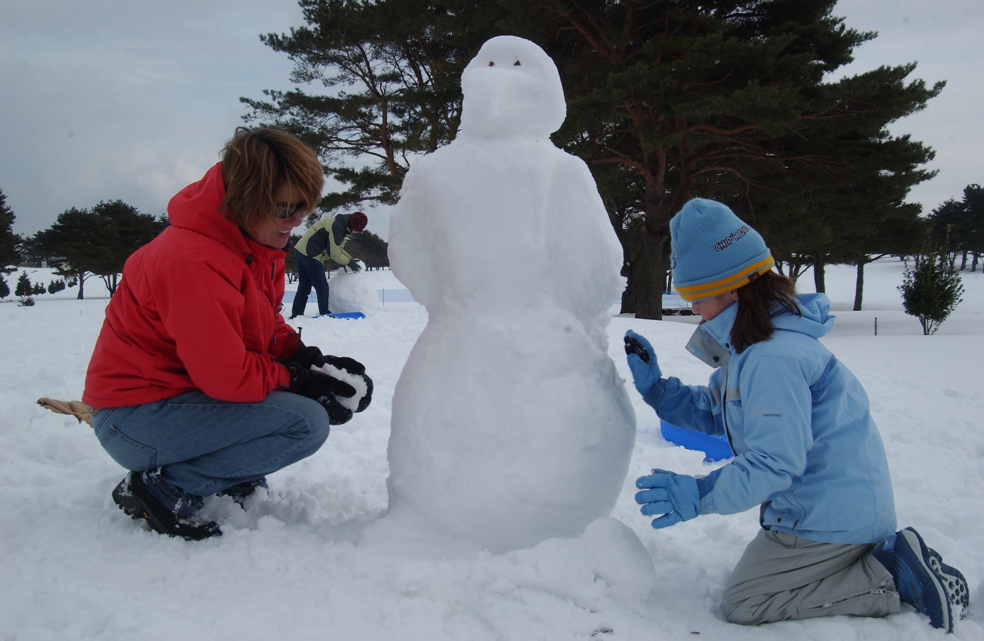 MISAWA AIR BASE, Japan -- Janet Schramel, and 8-year-old daughter Burke, build a snow penguin on the Golf Course during Winterfest on Feb. 3, 2008. The Winterfest, sponsored by the 35th Services Squadron and the Armed Forces Network, featured a snowman building contest, sledding and snowshoe races. (U.S. Air Force photo by Senior Airman Robert Barnett)