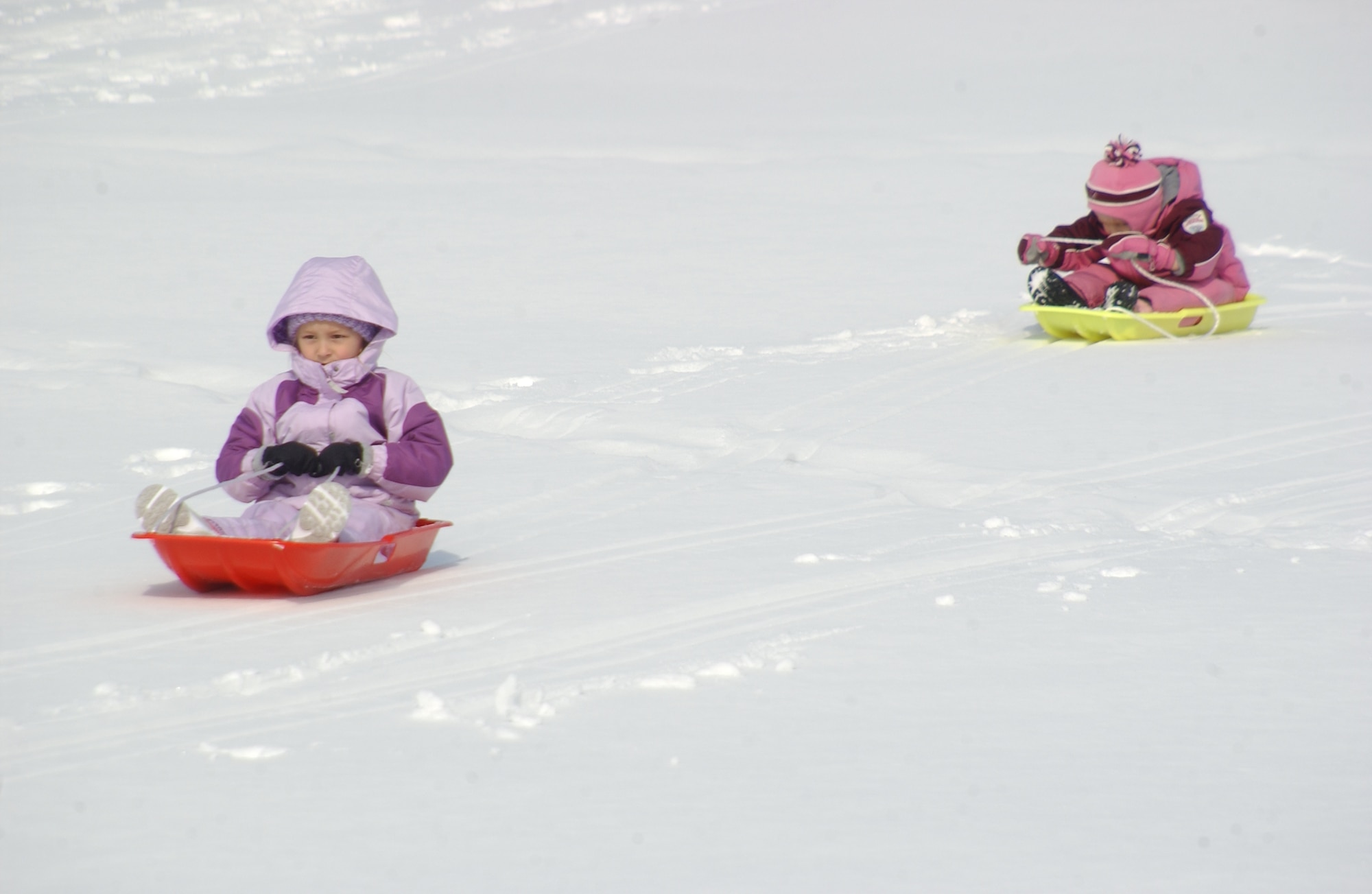MISAWA AIR BASE, Japan -- Ella Shaw leads the way as she and friend Teagen Lindgren, both 4 years old, sled on the Golf Course during a Winterfest Feb. 3, 2008. The Winterfest kicked of the 35th Services Squadron Customer Appreciation Week. (U.S. Air Force photo by Senior Airman Robert Barnett)