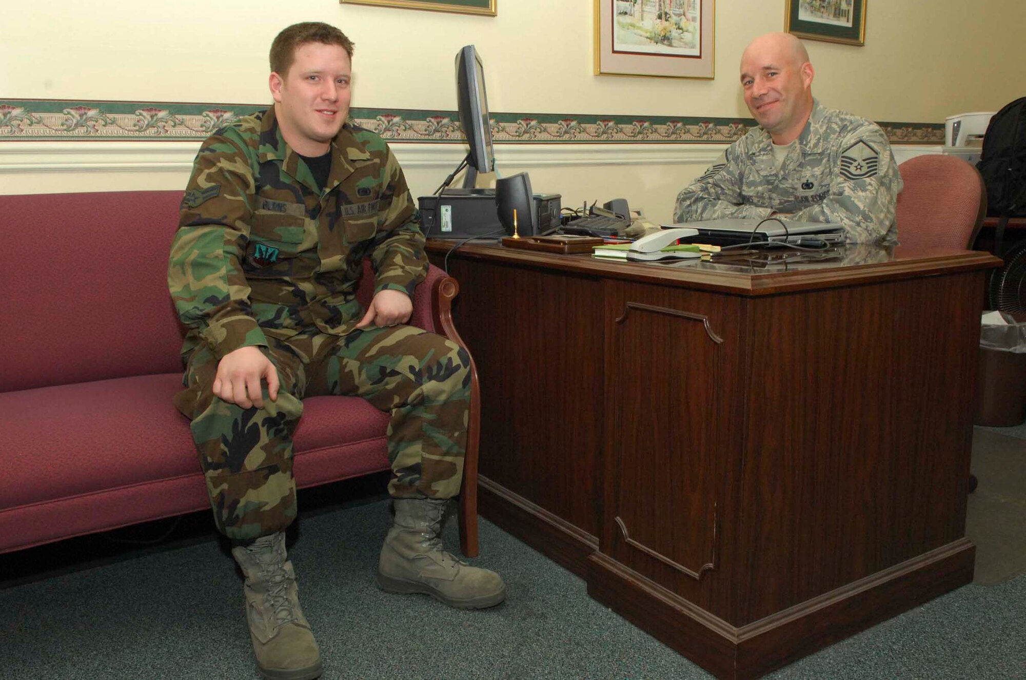SHAW AIR FORCE BASE, S.C.-- Airman 1st Class Bryan Burns, 20th Logistics Readiness Squadron customer service representative, visits his father, Master Sgt. Michael Burns, 20th LRS customer service NCO in charge. Airman Burns began working down the hall from his father two months ago. (U.S. Air Force photo/Staff Sgt. Henry Hoegen