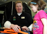 MINOT AIR FORCE BASE, N.D. – Shane Larson, the director of Outdoor Recreation, shows group of young girl how an ice fishing tip-up works at the Child Development Center here Feb. 6.  The ice fishing exhibit was a learning activity that was part of the CDC’s Winter Fest. (U.S. Air Force photo by Staff Sgt. Thomas Dow)