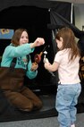 MINOT AIR FORCE BASE, N.D. – Rachel Filkins, the assistant director of Outdoor Recreation, shows an exited little girl the fish she “caught” in an ice house at the Child Development Center Feb. 6.  The ice fishing exhibit was a learning activity that was part of the CDC’s Winter Fest. (U.S. Air Force photo by Staff Sgt. Thomas Dow)