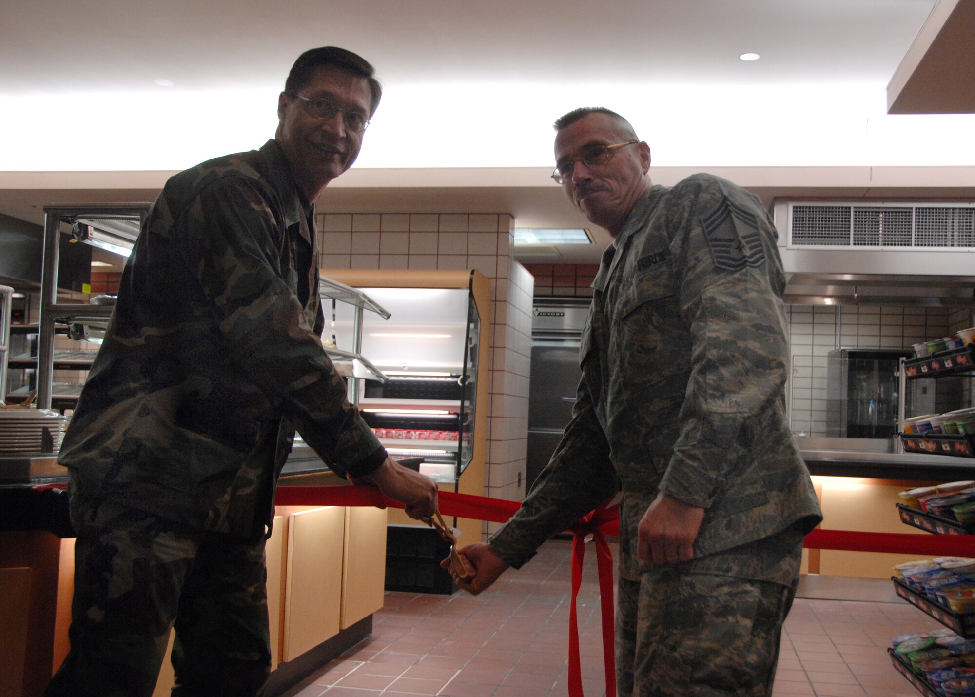 EIELSON AIR FORCE BASE, Alaska--Col. John Stutts, 354th Mission Support Group commander, and Chief Master Sgt. Richard Womer, 354th MSG superintendent, cut the ribbon for the newly-redesigned dining facility the morning of Feb. 6. The DFAC underwent a 10-week renovation, which refurbished facilities such as the serving lines and kitchen equipment to better serve facility-goers, especially during base exercises such as RED FLAG-Alaska. (U.S. Air Force photo by Airman 1st Class Christopher Griffin)