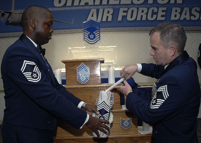 Senior Master Sgt. Christopher Riley, 437th Maintenance Group, and Chief Master Sgt. James Hobson, 315th Maintenance Squadron, light a candle symbolizing the progression of the enlisted force at the Chief Master Sergeant Recognition ceremony at the Charleston Club Feb. 2. Five new chief master sergeant promotees from both the 437th and 315th Airlift Wings were recognized during the ceremony. (U.S. Air Force photo/Airman 1st Class Katie Gieratz) 