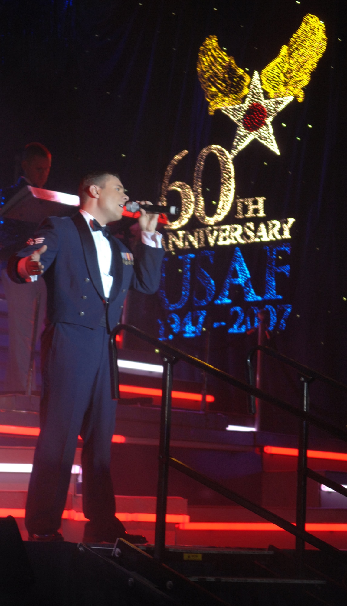 SEDALIA, Mo. – Senior Airman Nicholas Amari, a Tops in Blue vocalist, performs during the musical tribute “The Fly-By” at the Mathewson Exhibition Center on the Missouri State Fairgrounds Jan. 31.  (U.S. Air Force photo/Airman 1st Class Stephen Linch)

