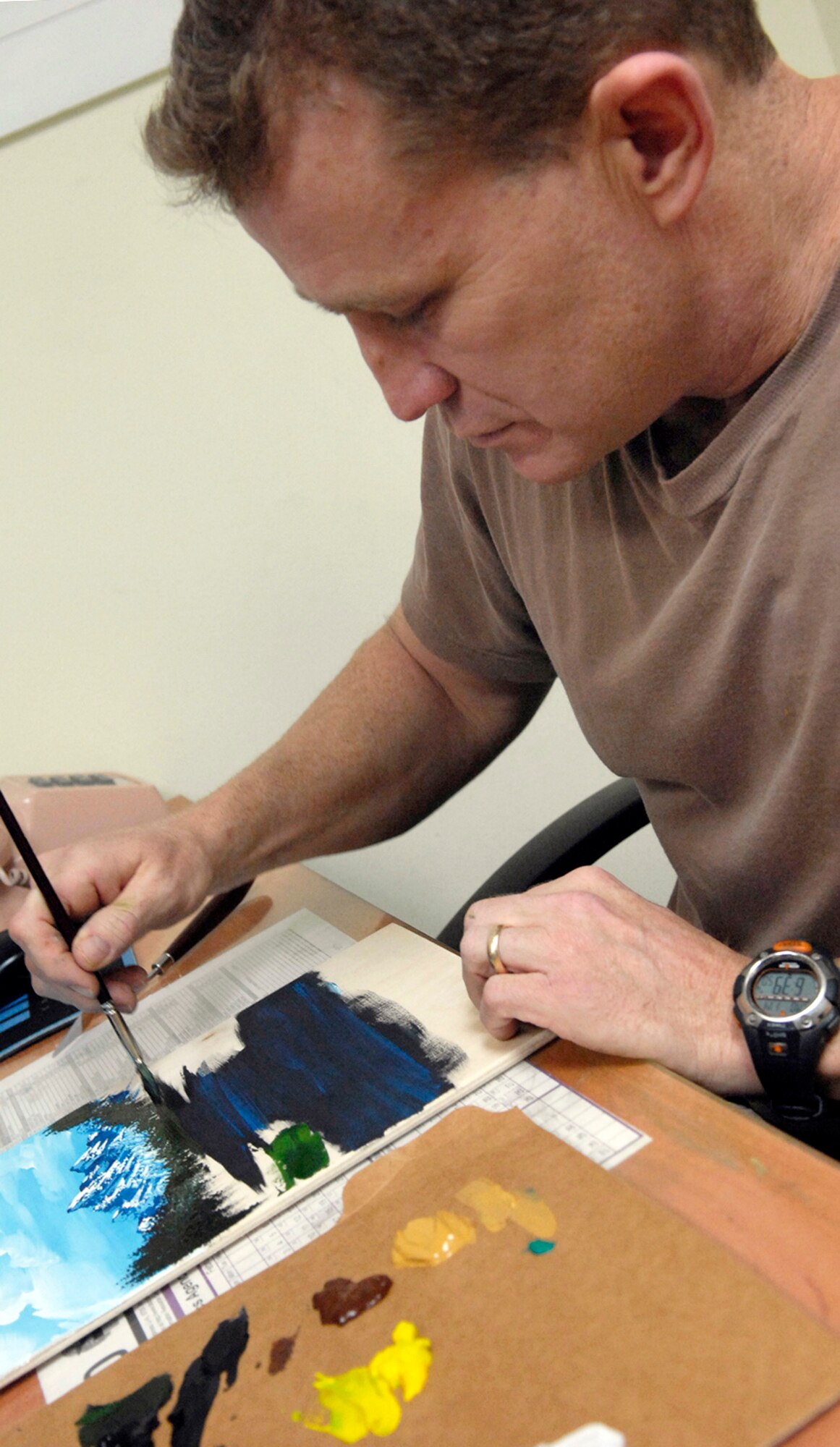 Tech. Sgt. Robert Sommers adds detail to a painting he is working on Jan. 14 at the 76th Expeditionary Civil Engineer Squadro at Manas Air Base, Kyrgyzstan, on his off-duty time. Sergeant Sommers sells the paintings he creates from leftover wood scraps and donates the proceeds to a local heart foundation that helps pay for heart surgeries for children whose parents are unable to pay for the surgeries themselves. Sergeant Sommers is the 376th ECES operations management NCO in charge. (U.S. Air Force photo/Senior Airman Tabitha Kuykendall) 