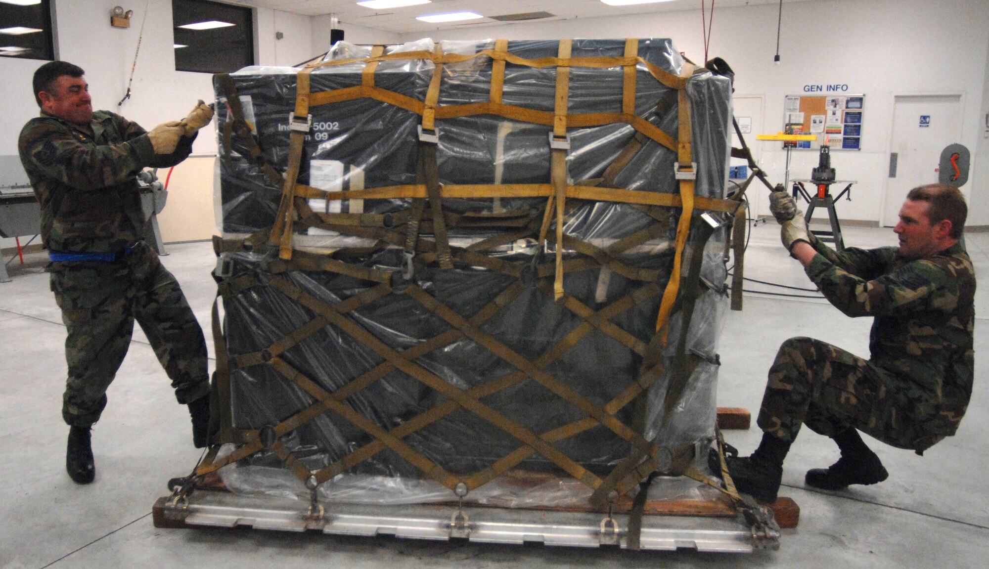 MOUNTAIN HOME AIR FORCE BASE, Idaho-- Technical Sgt. John Deegan and Technical Sgt. Daniel Ross, 366th Equipment Maintenance Squadron, tighten the cargo net on a pallet during phase I of Sharpshooter 08-03 Operation Readiness Exercise here Feb. 2. Units across the base are participating in the exercise to prepare personnel and equipment for the upcoming March 2008 Operational Readiness Inspection. (U.S. Air Force photo/ Airman 1st Class Stephany Miller)