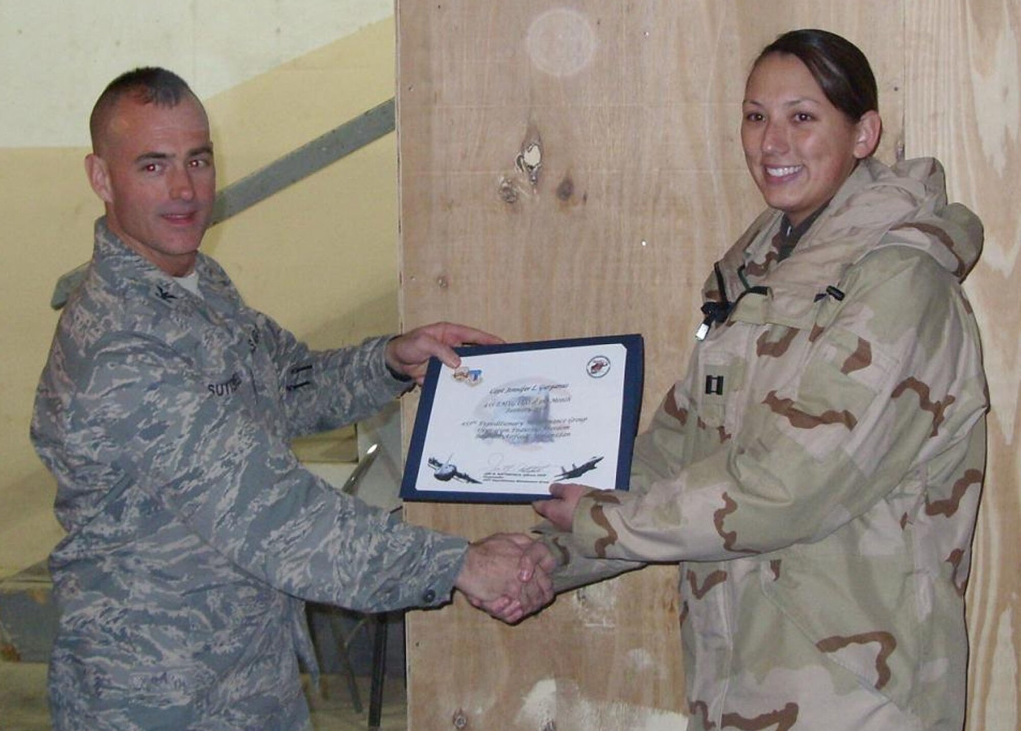 BAGRAM AIR BASE, Afghanistan -- Col. Jon Sutterfield, 455th Expeditionary Maintenance Group commander, presents Capt. Jennifer Gurganus, 455th Expeditionary Aircraft Maintenance Unit, a certificate for being named the 455th Air Expeditionary Wing company grade officer for the month of January. Captain Gurganus is deployed from Spangdahlem Air Base, Germany. (U.S. Air Force photo/Lt. Col. Richard Simmons)