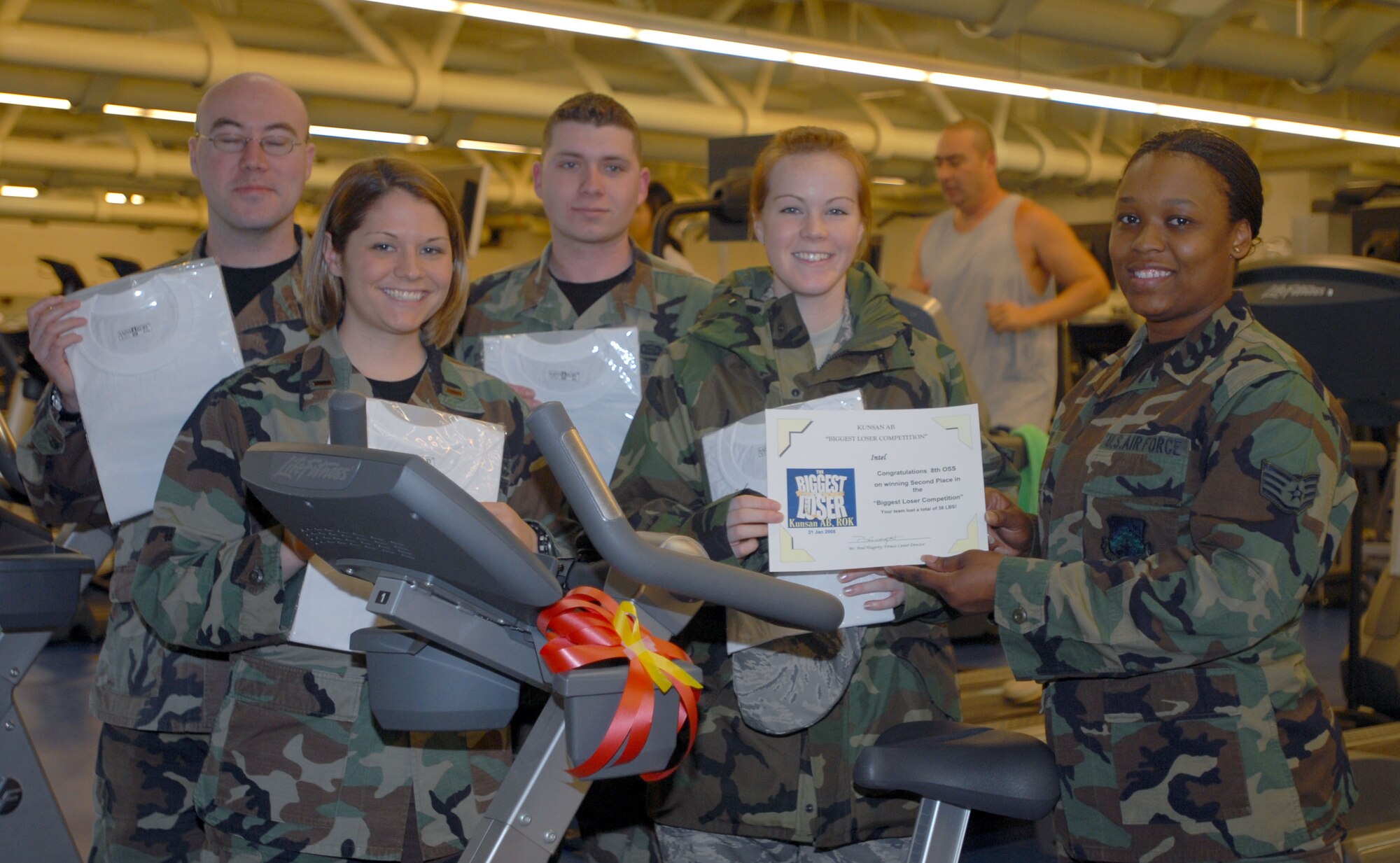 KUNSAN AIR BASE, South Korea -- Staff Sgt. Theresa Ross, special events coordinator for the 8th Services Squadron fitness center presents the 8th Operations Support Squadron's "Intel" with the second place award during the Biggest Loser awards ceremony here Feb. 6.  "Intel" completed the competition with a team weight-loss of 38 pounds.  The Biggest Loser competition is one of the many events that the fitness center hosts to motivate Airmen to get fit to fight and maintain a healthy Air Force lifestyle.  (U.S. Air Force photo/Staff Sgt. Darcie Ibidapo)