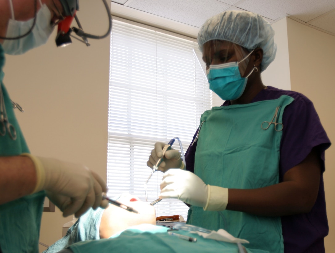MARINE CORPS BASE CAMP LEJEUNE, N.C. (Feb. 7, 2008) ? Mrs. Yvonne M. Amarh assists the dentist during a third-molar extraction procedure. Originally from Ghana, Africa, she came to the United States to work as a journalist, but instead switched to the dental surgery field.  She loves her job and works hard to give the best dental care to the Marines and Sailors of MCB Camp Lejeune. Amarh is a dental assistant with 2nd Dental Battalion, 2nd Marine Logistics Group.