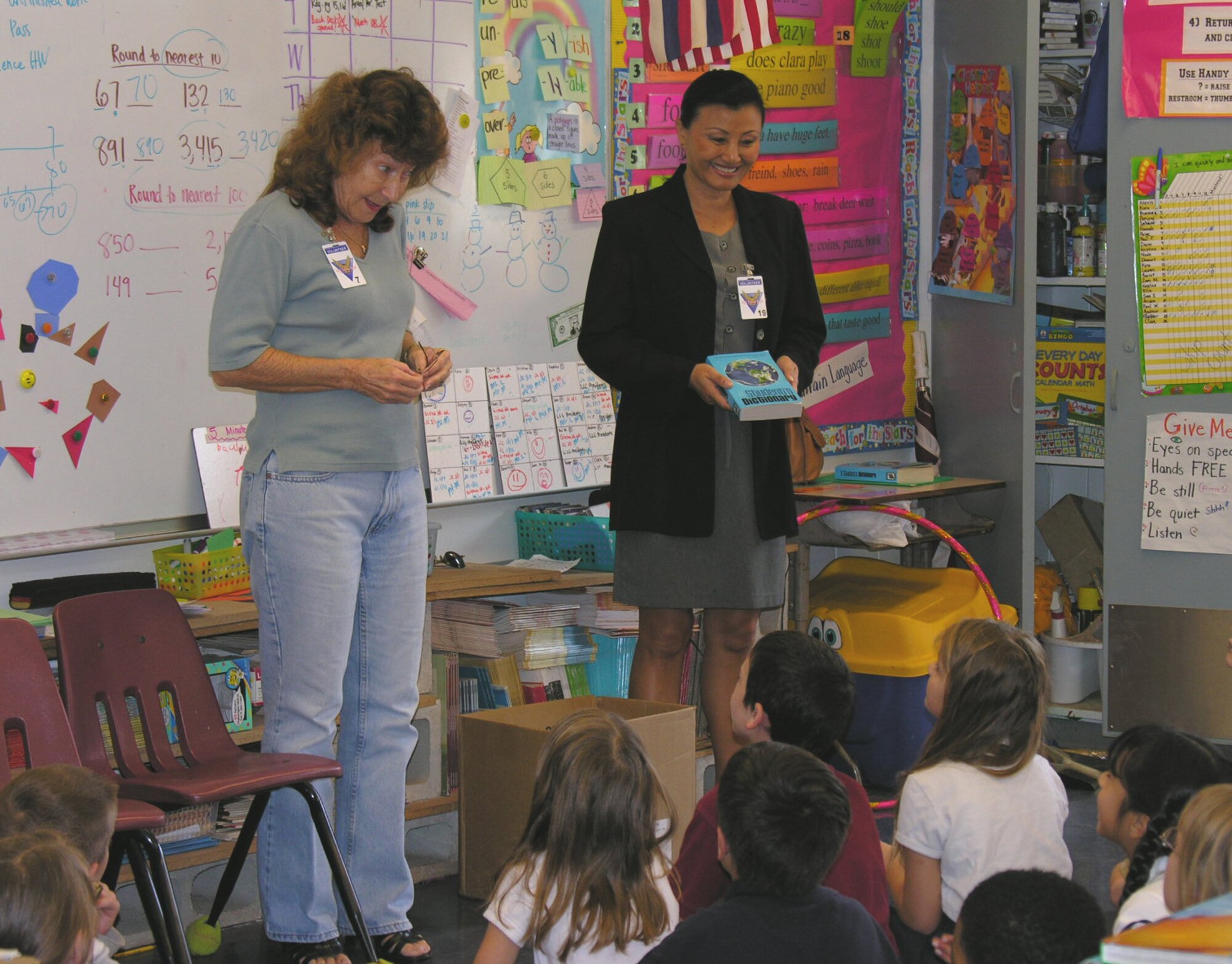 As part of a state-wide-effort, Connie Kraus (left), Rotary Club of Pearl Harbor Public Relations Director, and Jackie Hites, 15th Airlift wing Public Affairs Site Manager, distribute copies of "A Student's Dictionary" at Elementary Shcool. 