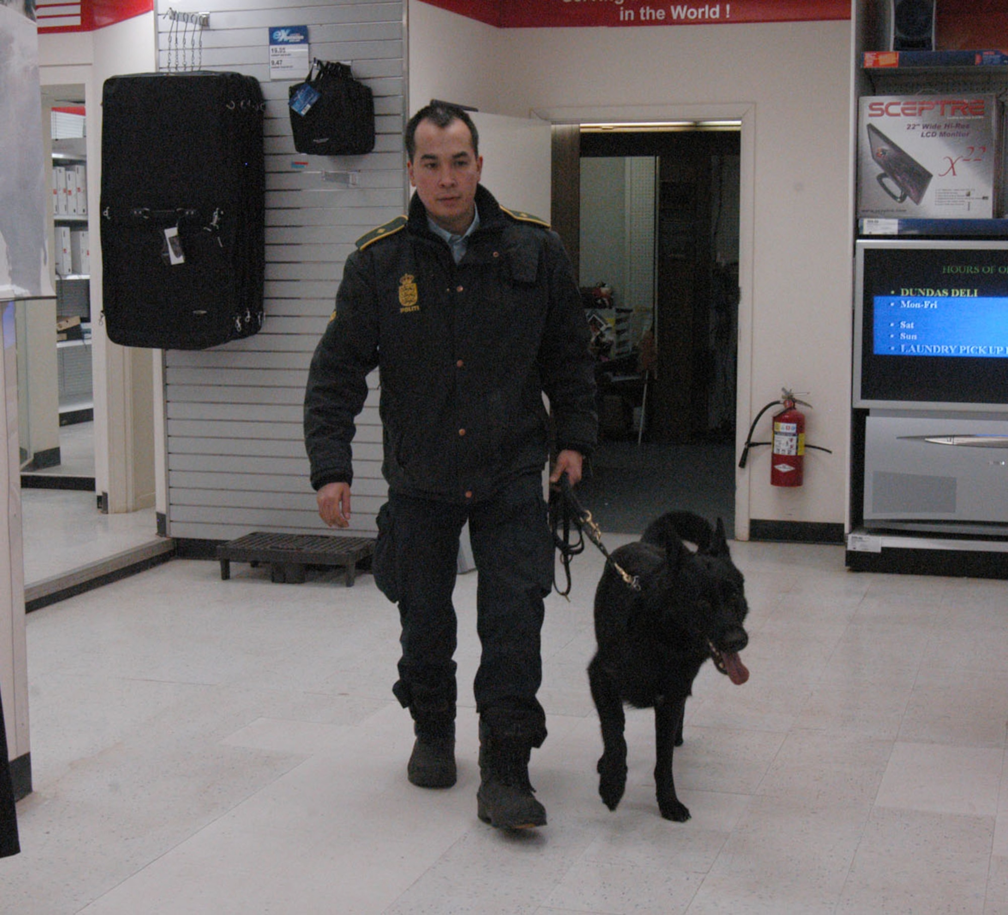 THULE AIR BASE, Greenland -- Farda Olsen, Danish Police Inspector, and Kenzo, a 4-year-old German Shepherd drug detecting dog, search the Thule Air Base Exchange for narcotics Jan. 25. Kenzo and Inspector Olsen visited Thule AB Jan. 25-28 and searched nearly 20 buildings and facilities. (U.S. Air Force photo/1st Lt. Nicole Langley)