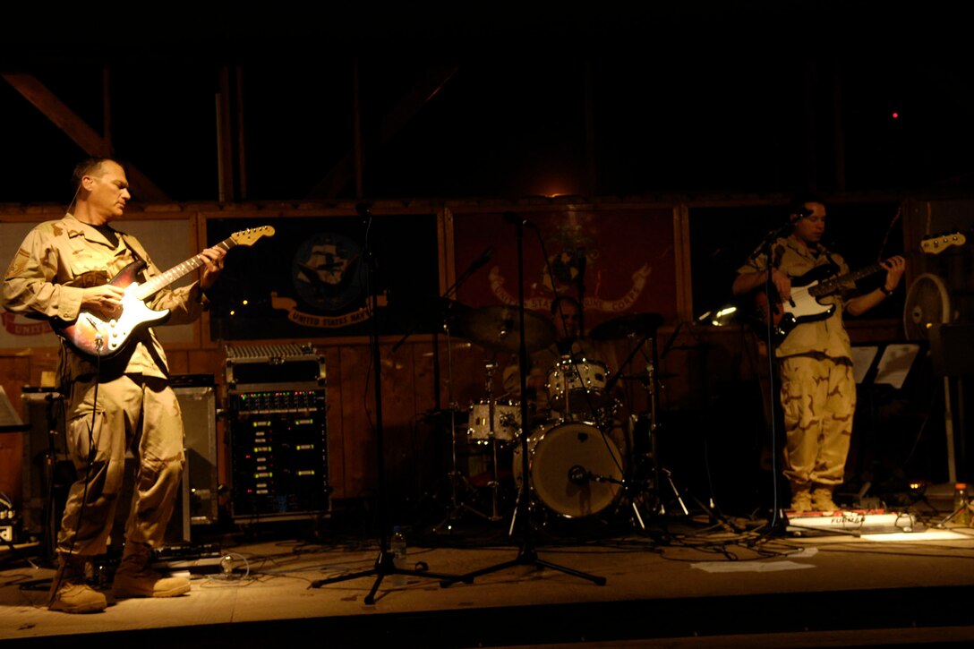 Members of Live Round (from left: SMSgt James Bristow, guitar; TSgt Henrique DeAlmeida, drums; MSgt Jeremy Laukhuf, bass) perform for troops in the Horn of Africa at Camp Lemonier, Djibouti. AF Photo by SSgt Christina Styer