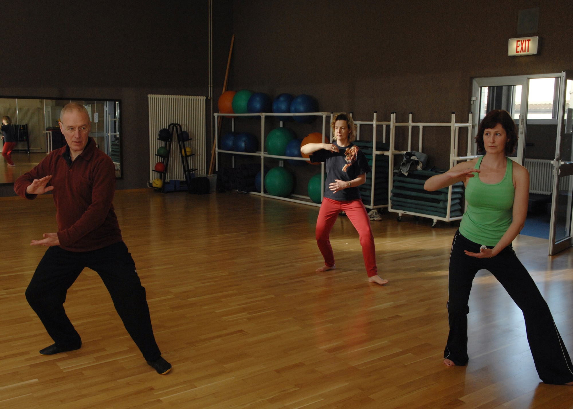 SPANGDAHLEM AIR BASE, Germany -- Klaus van den Boom, Tai Chi instructor, stretches with Kathy Plante and Colleen Colby during a Tai Chi class at the Skelton Memorial Fitness Center Feb. 7, 2008. This class is offered at Spangdahlem AB Mondays and Thursdays at 11 a.m. and at Bitburg Tuesdays and Thursdays at 6 p.m. (U.S. Air Force photo/Senior Airman Logan Tuttle)