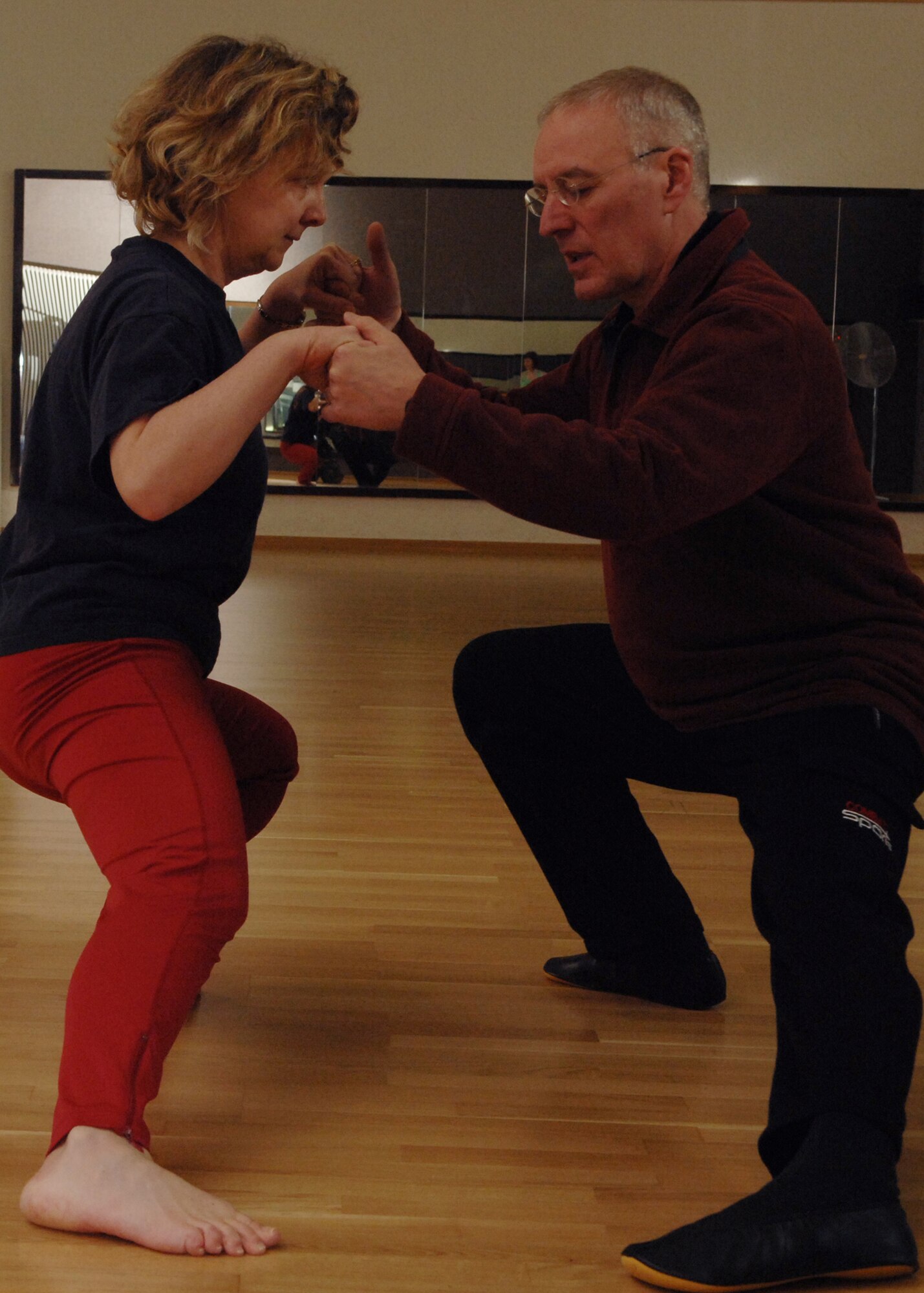 SPANGDAHLEM AIR BASE, Germany -- Kathy Plante stretches with Klaus van den Boom, Tai chi instructor, to stretch during a Tai Chi class at the Skelton Memorial Fitness Center Feb. 7, 2008. The class is intended to teach members and their dependants the basics of Tai Chi. (U.S. Air Force photo/Senior Airman Logan Tuttle)