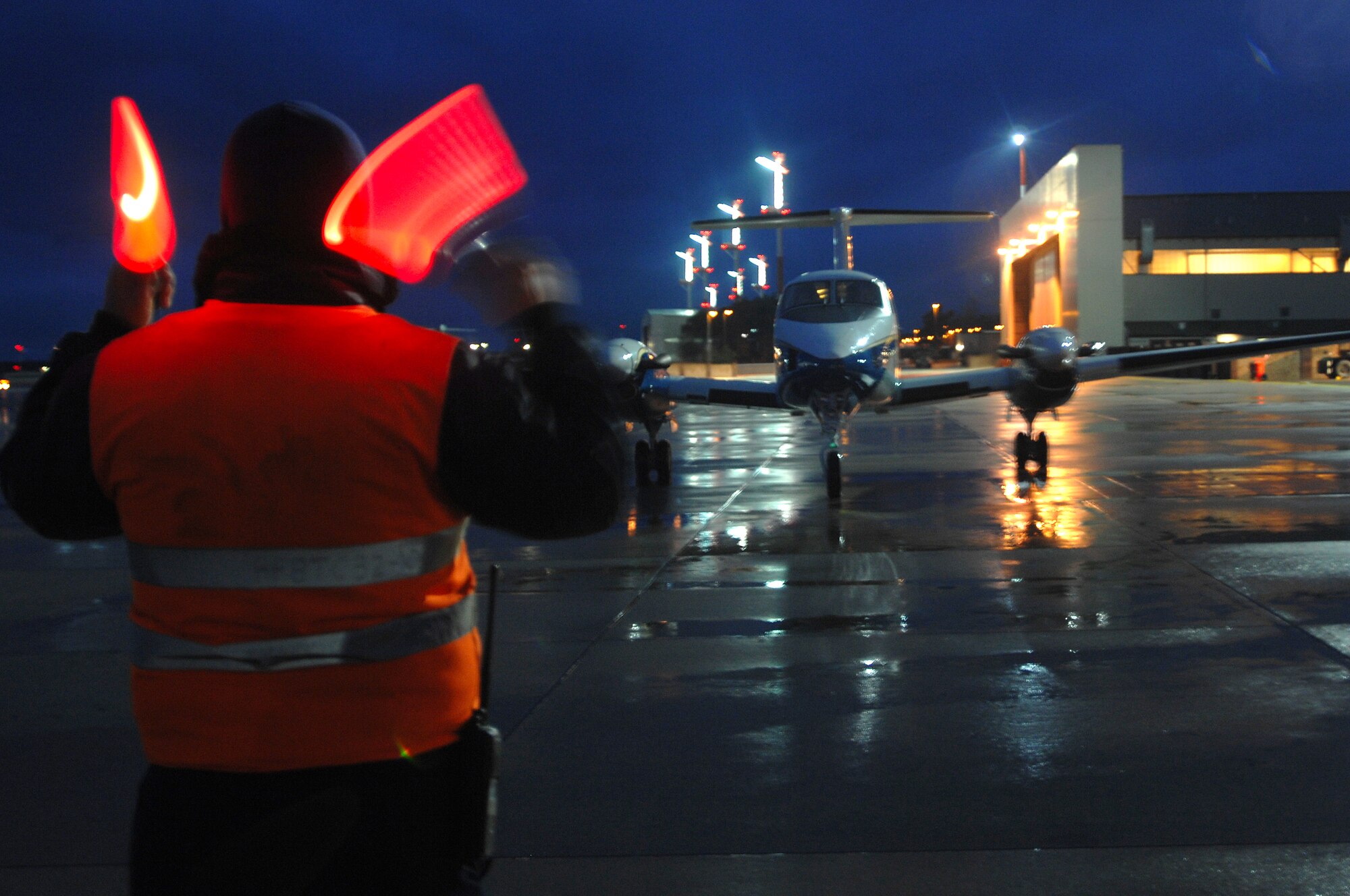 David Moore, Ramstein transient alert, guides a C-20 to its parking spot Feb. 5 on the Ramstein Air Base flightline. Lieutenant Gen. Laszlo Tombol, Commander Hungarian Joint Forces Command, is visiting with the 3rd Air Force. (U.S. Air Force Photo/Airman 1st Class Kenny Holston)