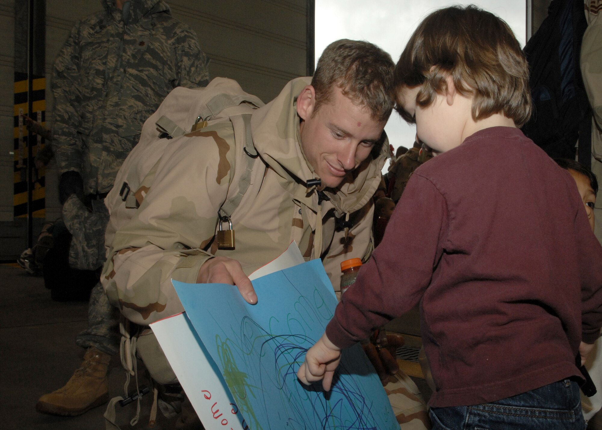 SPANGDAHLEM AIR BASE, Germany – Staff Sgt. Vincent Bousa, 52nd Equipment Maintenance Squadron, reads a sign his son, Brody, helped make for him after returning from a deployment in support of Operation Iraqi Freedom Feb. 6, 2008. (U.S. Air Force photo/Senior Airman Logan Tuttle)