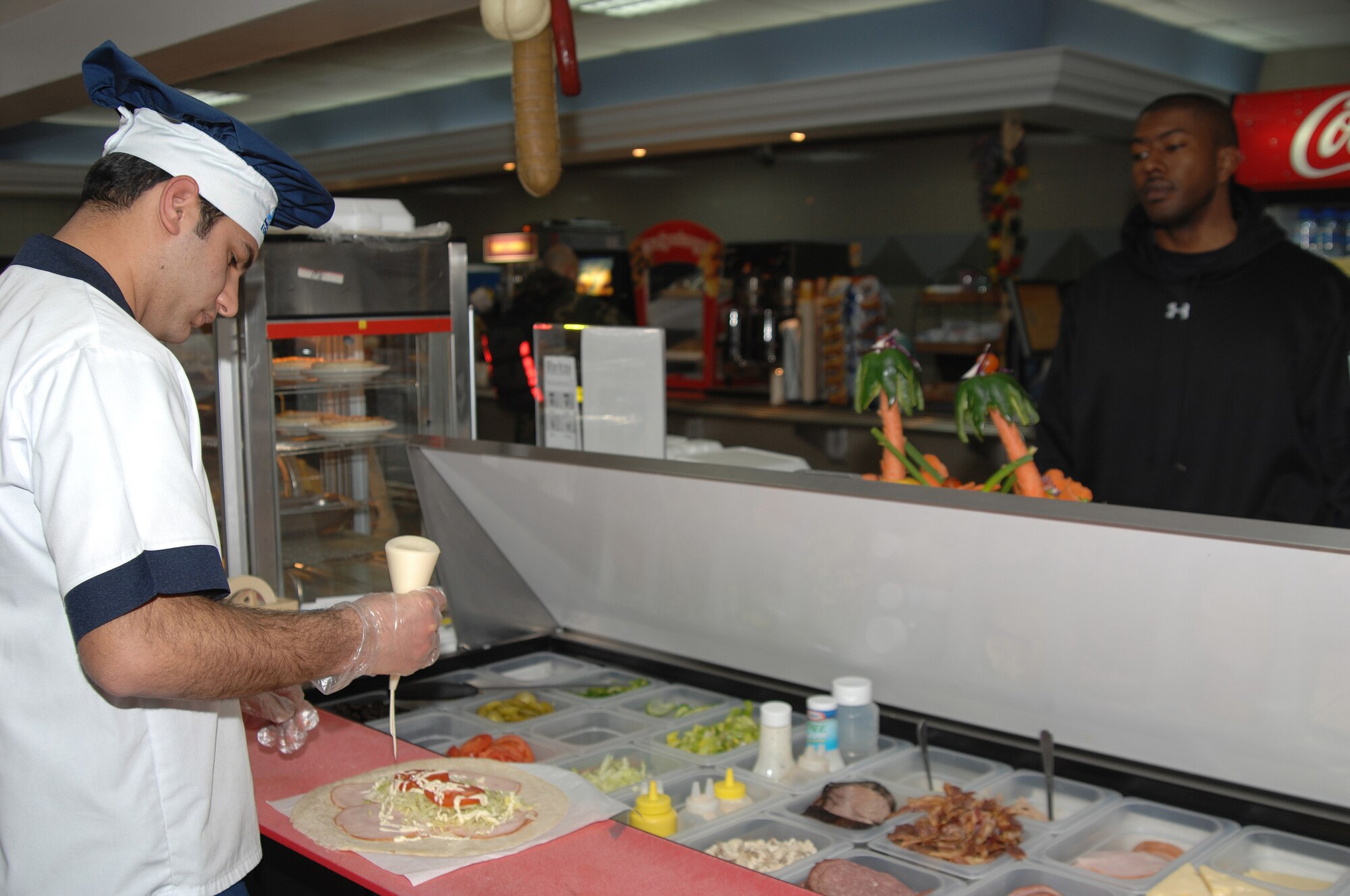 Serkan Kocaaaslan (left), 39th Services Squadron prepares a wrap for Staff Sgt. Raphael Simmons, 817th Expeditionary Airlift Squadron at the Sultan's Inn Dining Facility Feb. 4. (U.S. Air Force photo by Senior Airman Lauren Padden)