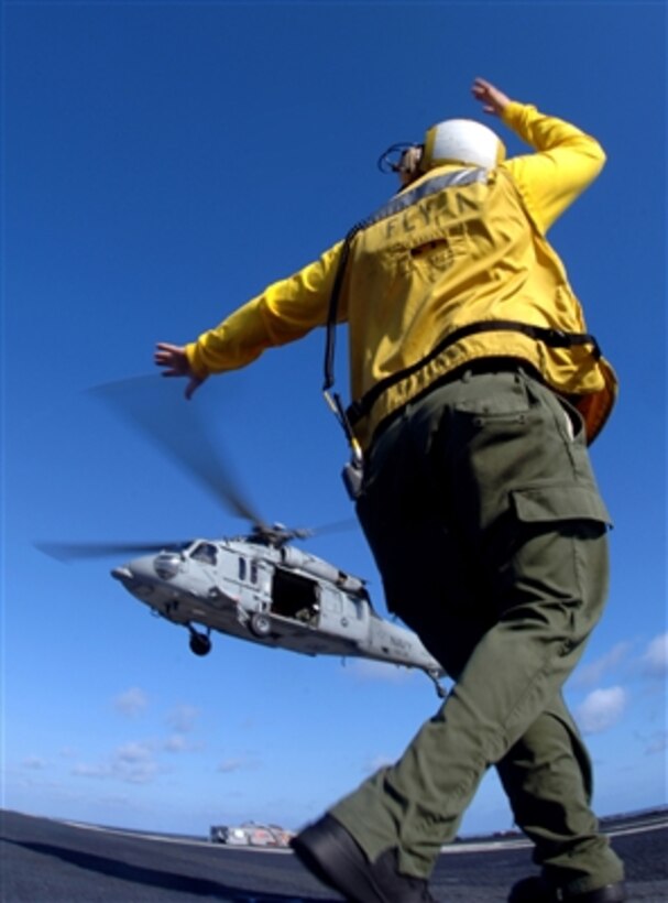 A U.S. Navy flight deck crewman signals to the pilot of an MH-60S Seahawk helicopter during vertical replenishment operations on the flight deck of the aircraft carrier USS Theodore Roosevelt (CVN 71) while under way in the Atlantic Ocean on Feb. 5, 2008.  The Seahawk is assigned to Helicopter Combat Support Squadron 26.  