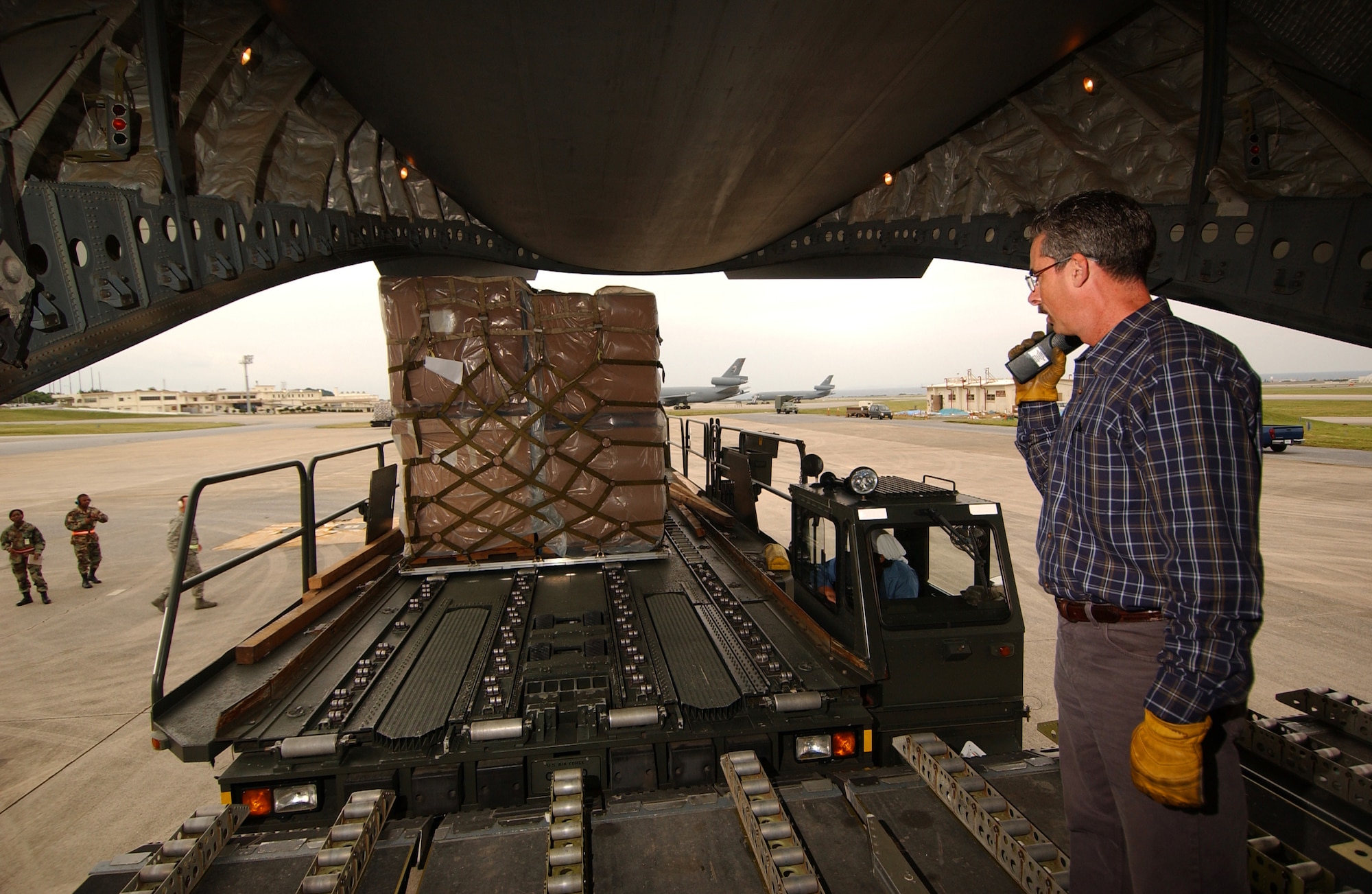 KADENA AIR BASE, Okinawa -- Stephen Gambert, 733rd Air Mobility squadron load planner, radios in the status of the cargo to the air terminal operations center here Feb. 8. The 733rd AMS loaded medical supplies, food rations and cold weather gear onto this C-17 from Elmendorf Air Force Base, Alaska, and another from Hickam Air Force Base, Hawaii, bound for China.  Recently, 19 Chinese provinces experienced the most severe winter storms in 50 years, imposing severe hardships on millions of Chinese citizens.  U.S. Pacific Command coordinated the delivery of the humanitarian supplies to People’s Liberation Army at Shanghai International Airport, China.    (U.S. Air Force photo/Tech. Sgt. Rey Ramon)
