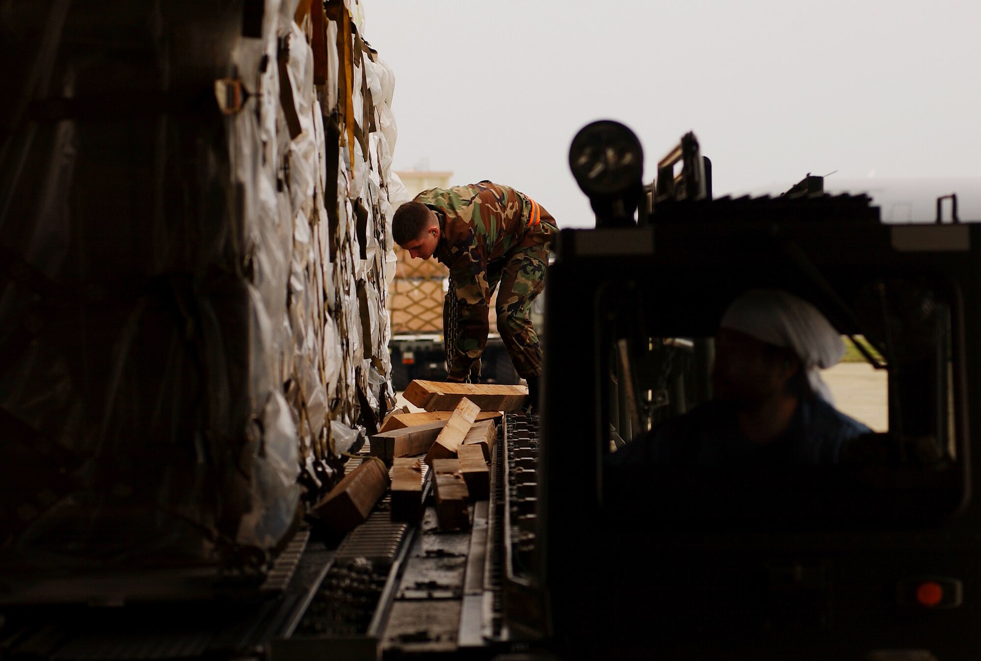 KADENA AIR BASE, Okinawa -- Airman 1st Class Patrick Lorensen, 733rd Air Mobility Squadron air transportation specialist, removes chains used to tie down cargo pallets before loading them onto a C-17 Globemaster III, Feb. 8. The 733rd AMS loaded medical supplies, food rations and cold weather gear onto this C-17 from Elmendorf Air Force Base, Alaska, and another from Hickam Air Force Base, Hawaii, bound for China.  Recently, 19 Chinese provinces experienced the most severe winter storms in 50 years, imposing severe hardships on millions of Chinese citizens.  U.S. Pacific Command coordinated the delivery of the humanitarian supplies to People’s Liberation Army at Shanghai International Airport, China.   (U.S. Air Force photo/Tech. Sgt. Rey Ramon)