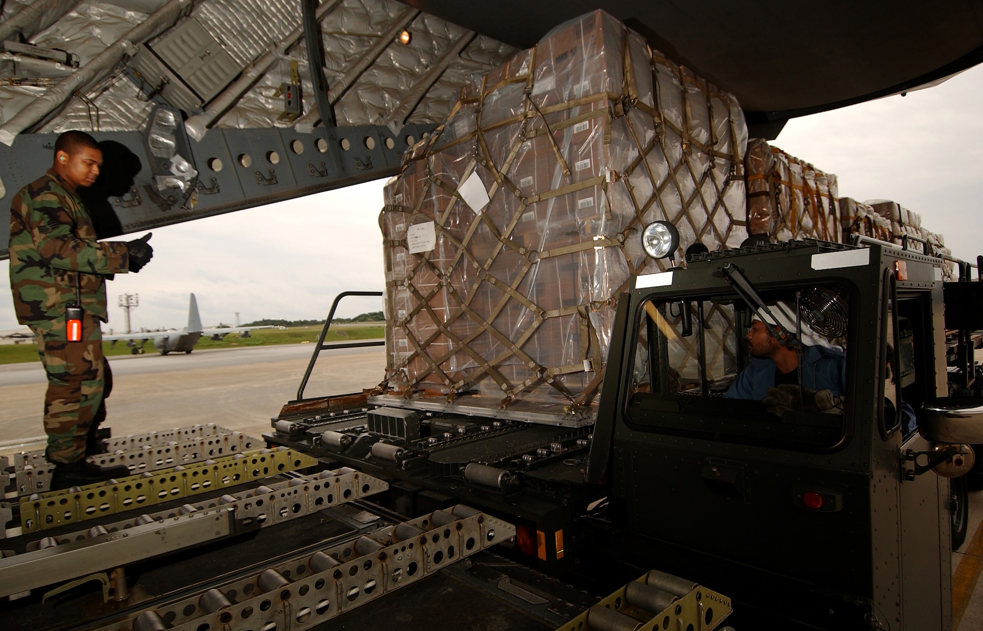 KADENA AIR BASE, Okinawa -- Senior Airman William Judge, 733rd Air Mobility Squadron air transportation specialist, guides cargo pallets onto a C-17 Globemaster III, Feb. 8. The 733rd AMS loaded medical supplies, food rations and cold weather gear onto this C-17 from Elmendorf Air Force Base, Alaska, and another from Hickam Air Force Base, Hawaii, bound for China.  Recently, 19 Chinese provinces experienced the most severe winter storms in 50 years, imposing severe hardships on millions of Chinese citizens.  U.S. Pacific Command coordinated the delivery of the humanitarian supplies to People’s Liberation Army at Shanghai International Airport, China.  (U.S. Air Force photo/Tech. Sgt. Rey Ramon)