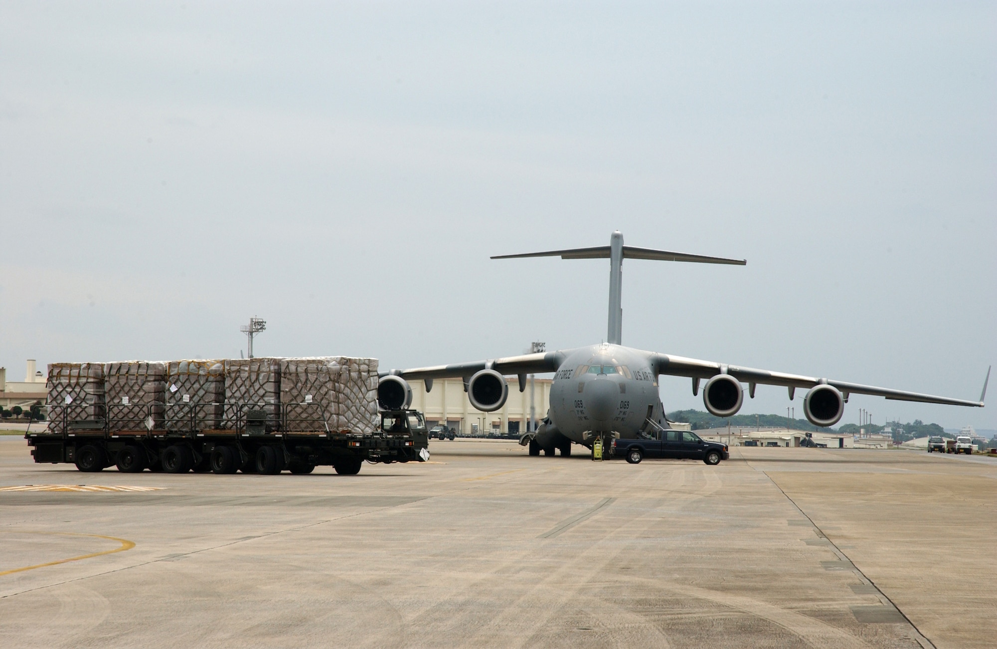 KADENA AIR BASE, Okinawa - A C-17 from Elmendorf Air Force Base, Alaska, sits on the ramp here while food and cold weather supplies prepare to be loaded onto another C-17 (not pictured) from Hickam Air Force Base, Hawaii, Feb. 8.  U.S. Pacific Command coordinated the delivery of the humanitarian supplies to People’s Liberation Army at Shanghai International Airport, China. Recently, 19 Chinese provinces experienced the most severe winter storms in 50 years, imposing severe hardships on millions of Chinese citizens. (U.S. Air Force Photo/Senior Airman Jeremy McGuffin)  