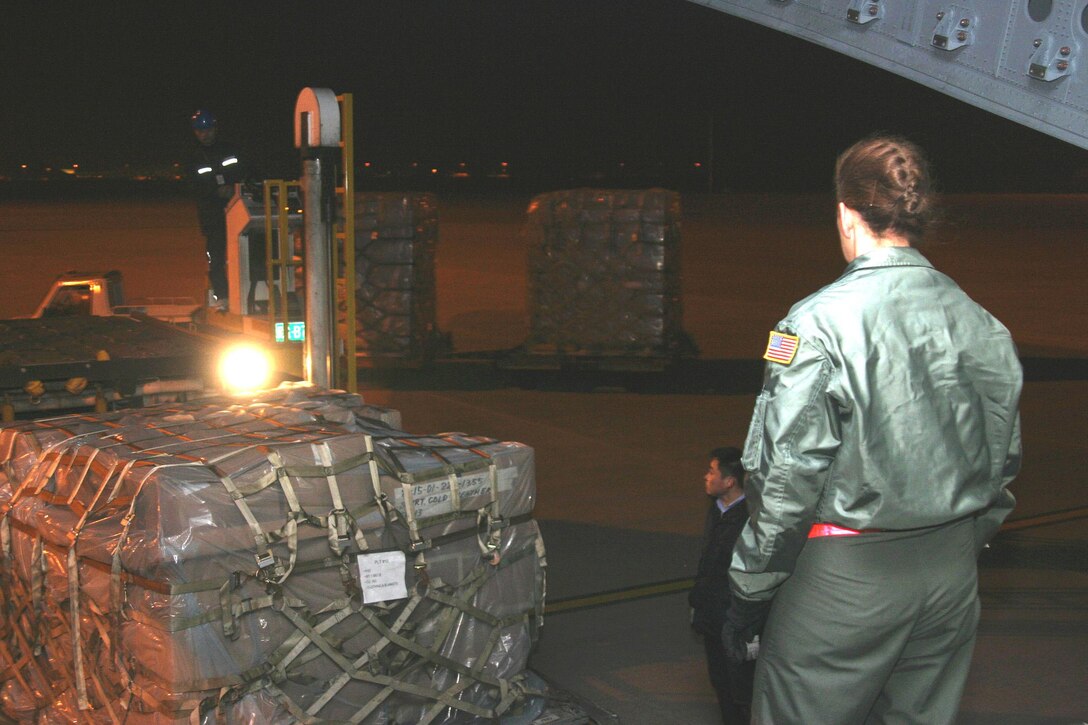 U.S. Air Force Senior Master Sgt. Jeanette King, 535th Airlift Squadron, 15th Airlift Wing, Hickam Air Force Base, Hawaii, directs the off-loading of a pallet of humanitarian relief supplies from a C-17 Globemaster III. Two C-17's, one from 15 AW, Hickam AFB, and the other from the 3rd Wing, Elmendorf Air Force Base, Alaska assisted in the deliver. Thirteenth Air Force's 613th Air and Space Operations Center Air Mobility Divsion at Hickam AFB coordinated the delivery of 225,890 pounds of relief supplies to Shanghai within 18 hours of Secretary of Defense approval. Recently, 19 Chinese provinces experienced the most severe winter storms in 50 years, imposing severe hardships on millions of Chinese citizens. (U.S. Marine Corps photo by Cpl. Anthony J. DeCapite)