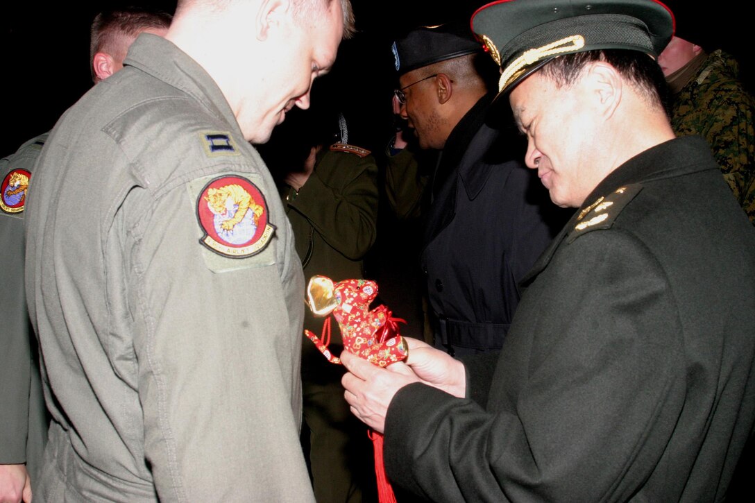 U.S. Air Force Capt. Dave Ericson receives a Chinese New Year's gift symbolizing the Chinese ?Year of the Rat? from Major General Lihua Qian of the People?s Liberation Army. Captain Ericson commanded the 15th Airlift Wing C-17 from Hickam Air Force Base, Hawaii, which delivered humanitarian supplies to the Shanghai International Airport. Thirteenth Air Force's 613th Air and Space Operations Center Air Mobility Divsion at Hickam AFB coordinated the delivery of 225,890 pounds of relief supplies to Shanghai within 18 hours of Secretary of Defense approval. Recently, 19 Chinese provinces experienced the most severe winter storms in 50 years, imposing severe hardships on millions of Chinese citizens. (U.S. Marine Corps photo by Cpl. Anthony J. DeCapite)