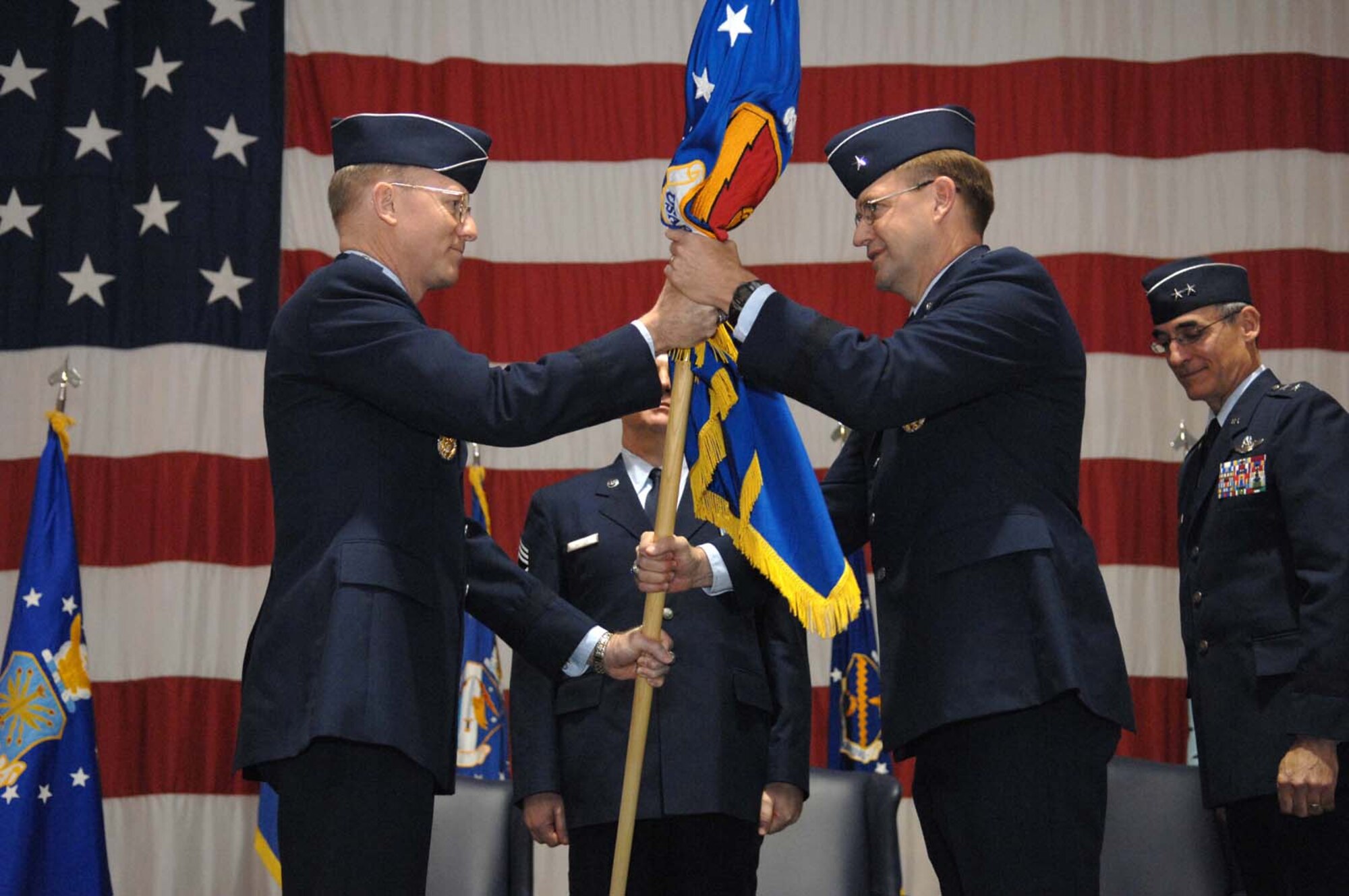 General John D.W. Corley (left), commander, Air Combat Command, passes the U.S. Air Force Warfare Center guidon to Brig. Gen. Stephen L. Hoog, incoming USAFWC commander, during the official USAFWC Change of Command ceremony Feb. 8, Nellis Air Force Base, Nev. (U.S. Air Force Photo by Senior Airman Larry E. Reid Jr.)