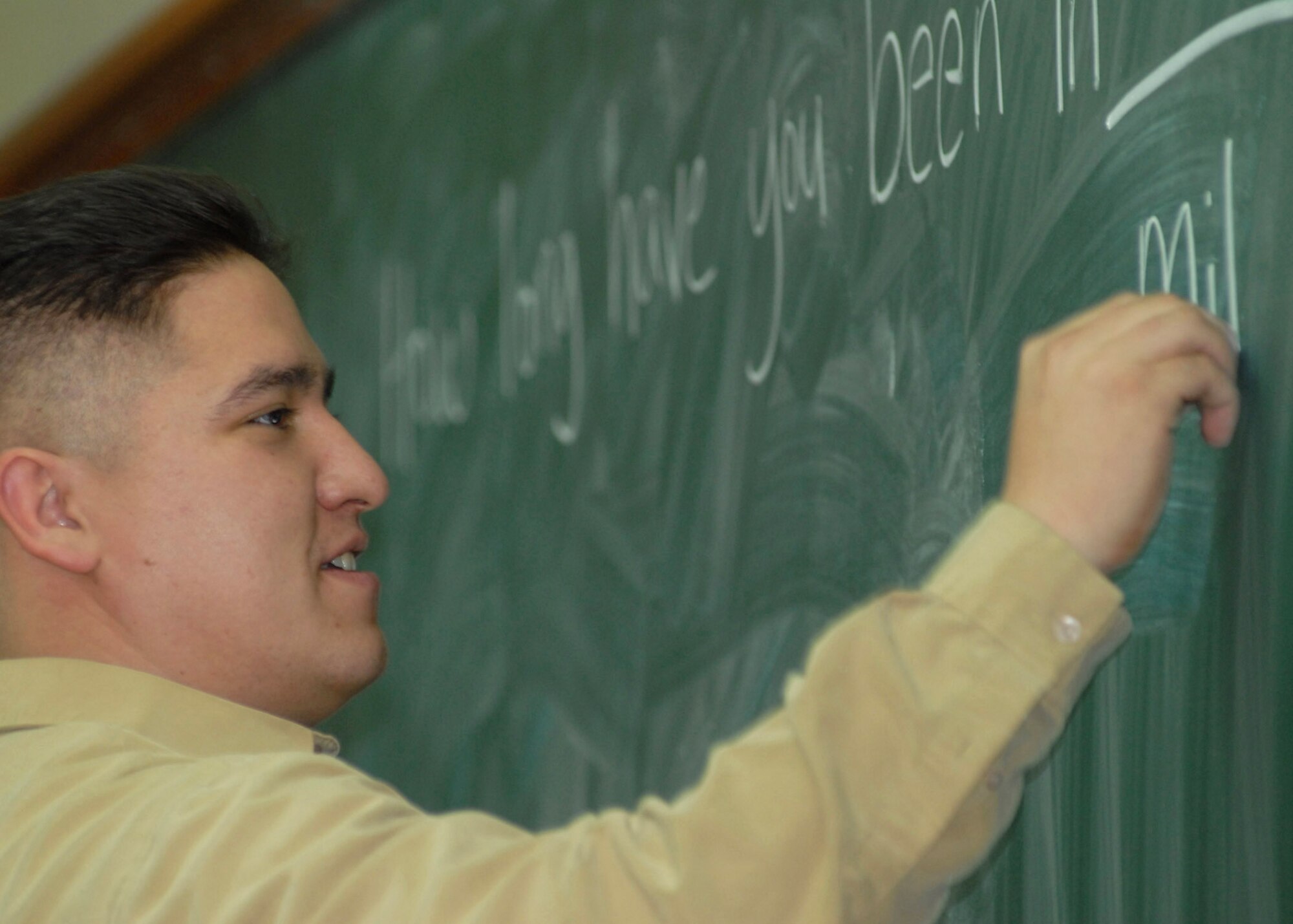 Staff Sgt. Jon Powell writes down common English greetings on the blackboard Jan. 31 at Kunsan Air Base, South Korea. Numerous Airmen from the 5/6 group volunteer to teach assist South Korean army cadets English. Sergeant Powell is the 8th Communications Squadron NCO in charge of visual imagery and intrusion detection systems and wideband maintenance. (U.S. Air Force photo/Staff Sgt. Araceli Alarcon) 
