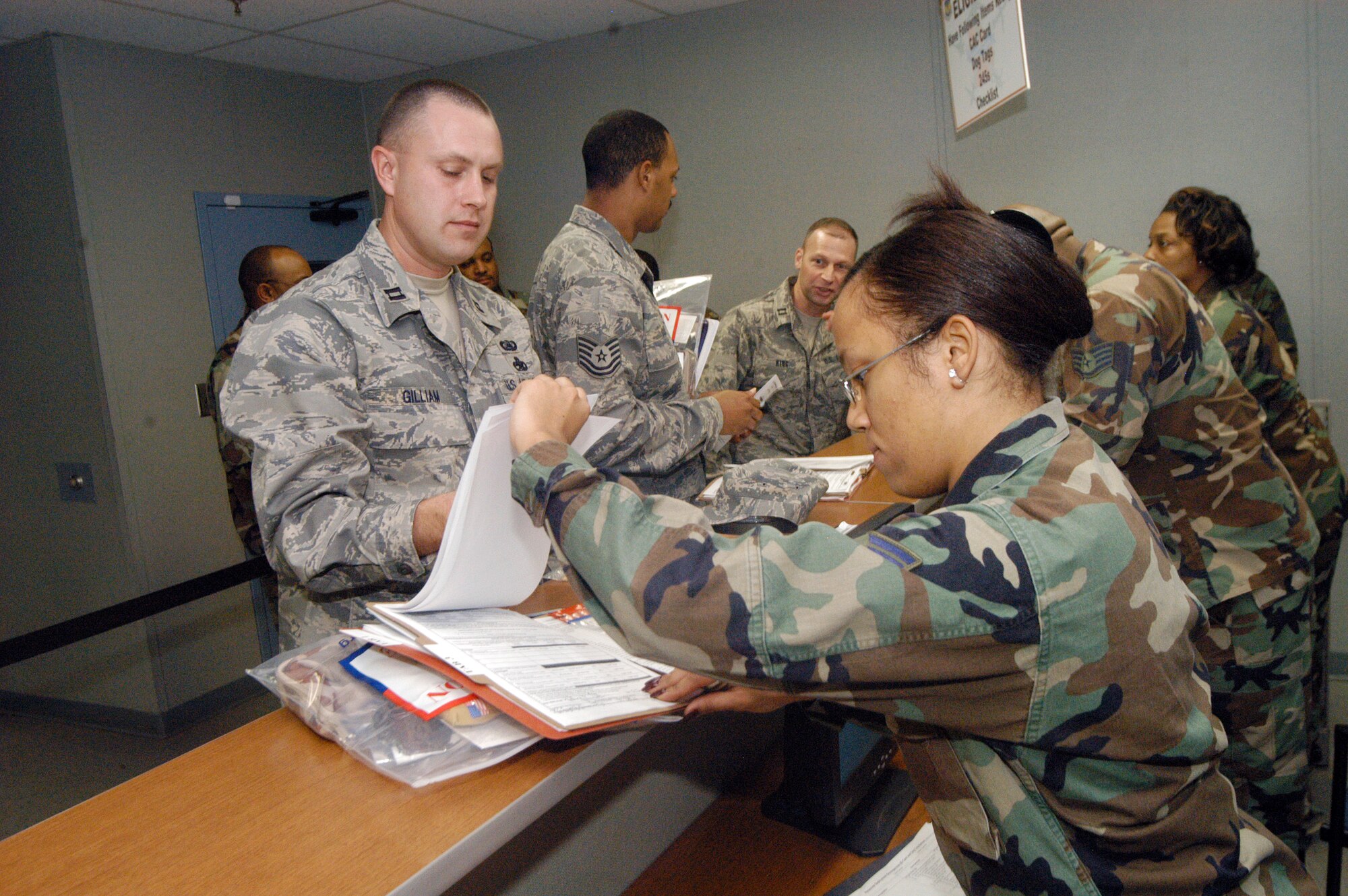 Capt Anthony Gilliam get his documentation checked by A1C Sarita Taylor during a pre-deployment processing line Feb. 1. U. S. Air Force photo by Sue Sapp  