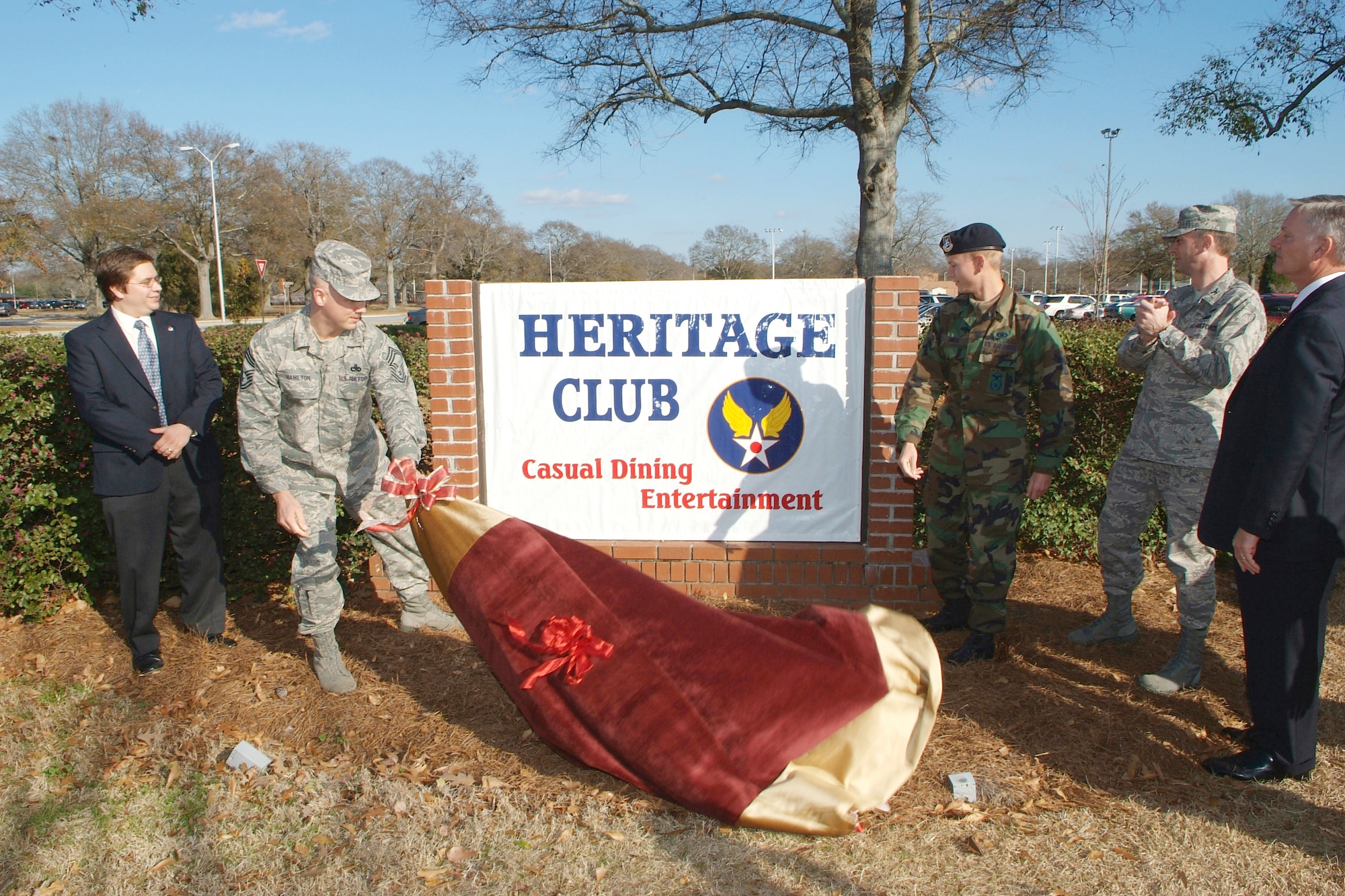 Chief MSgt. Kevin Hamilton, 19th Air Refueling Group command chief, helps unveil the new Heritage Club sign during the 78th Services Division unveiling ceremony Feb. 1 while 78th Services Division and 78th Air Base Wing leadership look on. U. S. Air Force photo by Gary Cutrell
