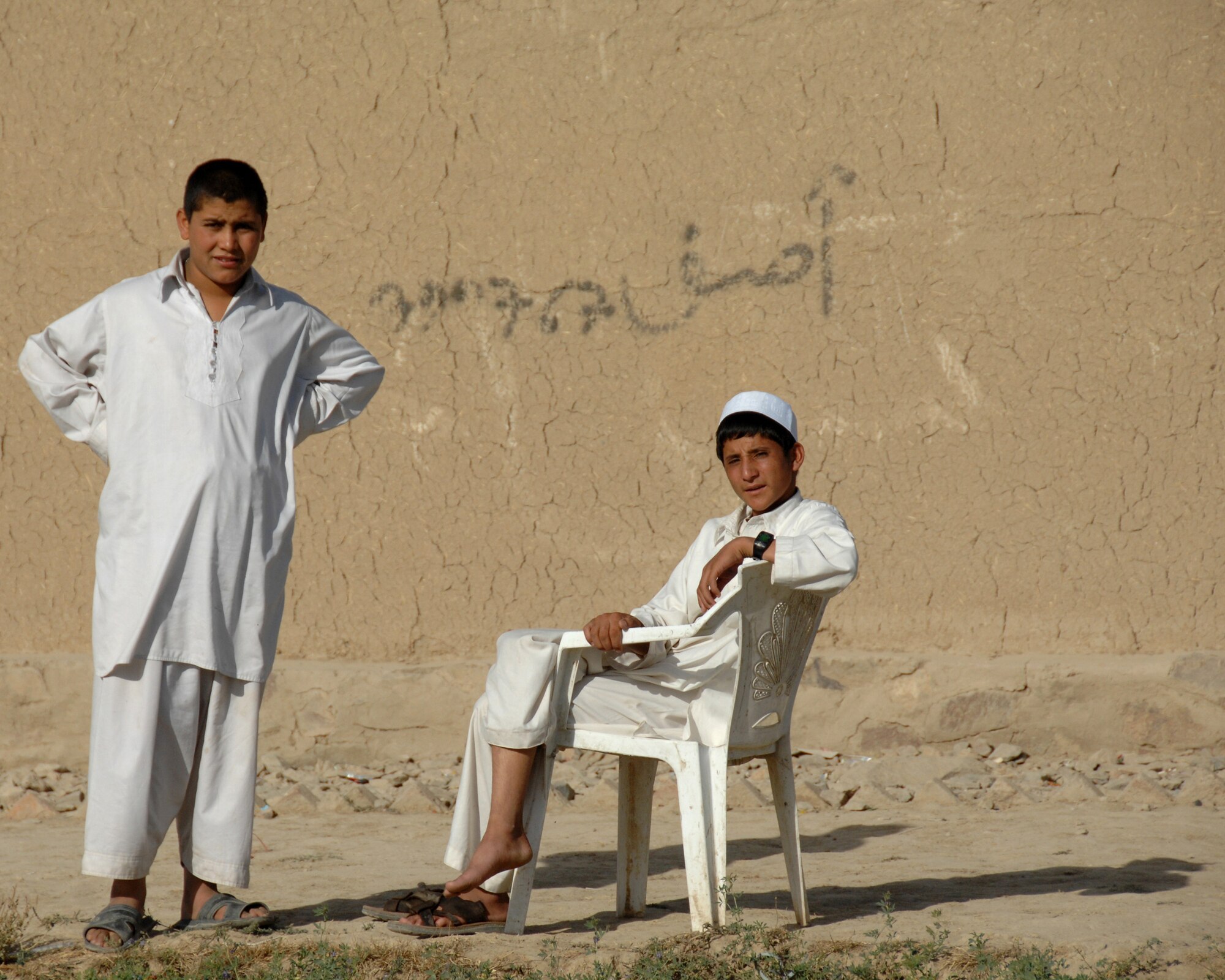 Afghan boys watch an International Security Assistance Force patrol pass through their village October 2007. (ISAF photo by Master Sgt. Russell P. Petcoff)