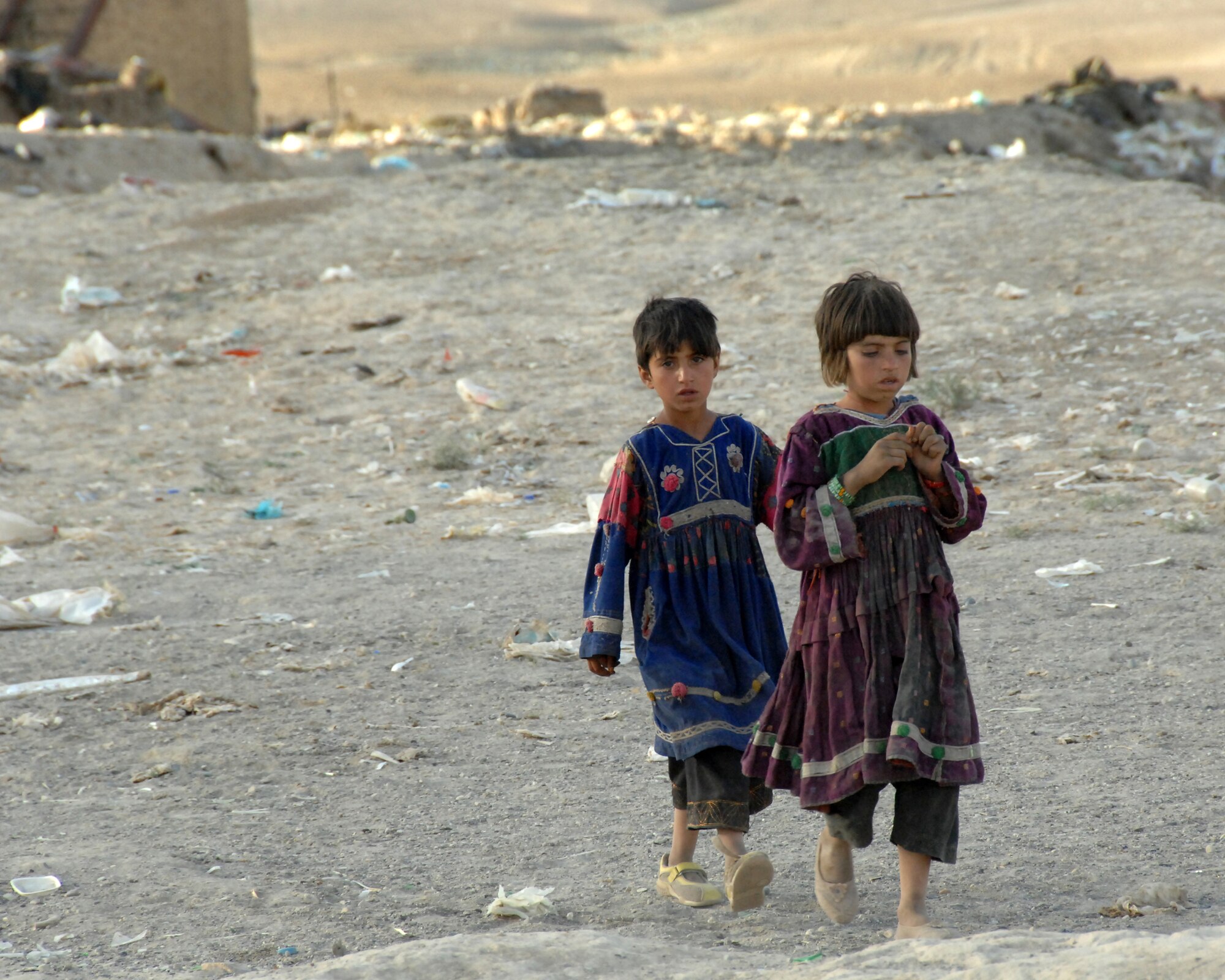Nomadic Kuchi girls walk through an abandoned Soviet-era artillery range where they lived.  International Security Assistance Force troops patrolled the village October 2007. (ISAF photo by Master Sgt. Russell P. Petcoff)