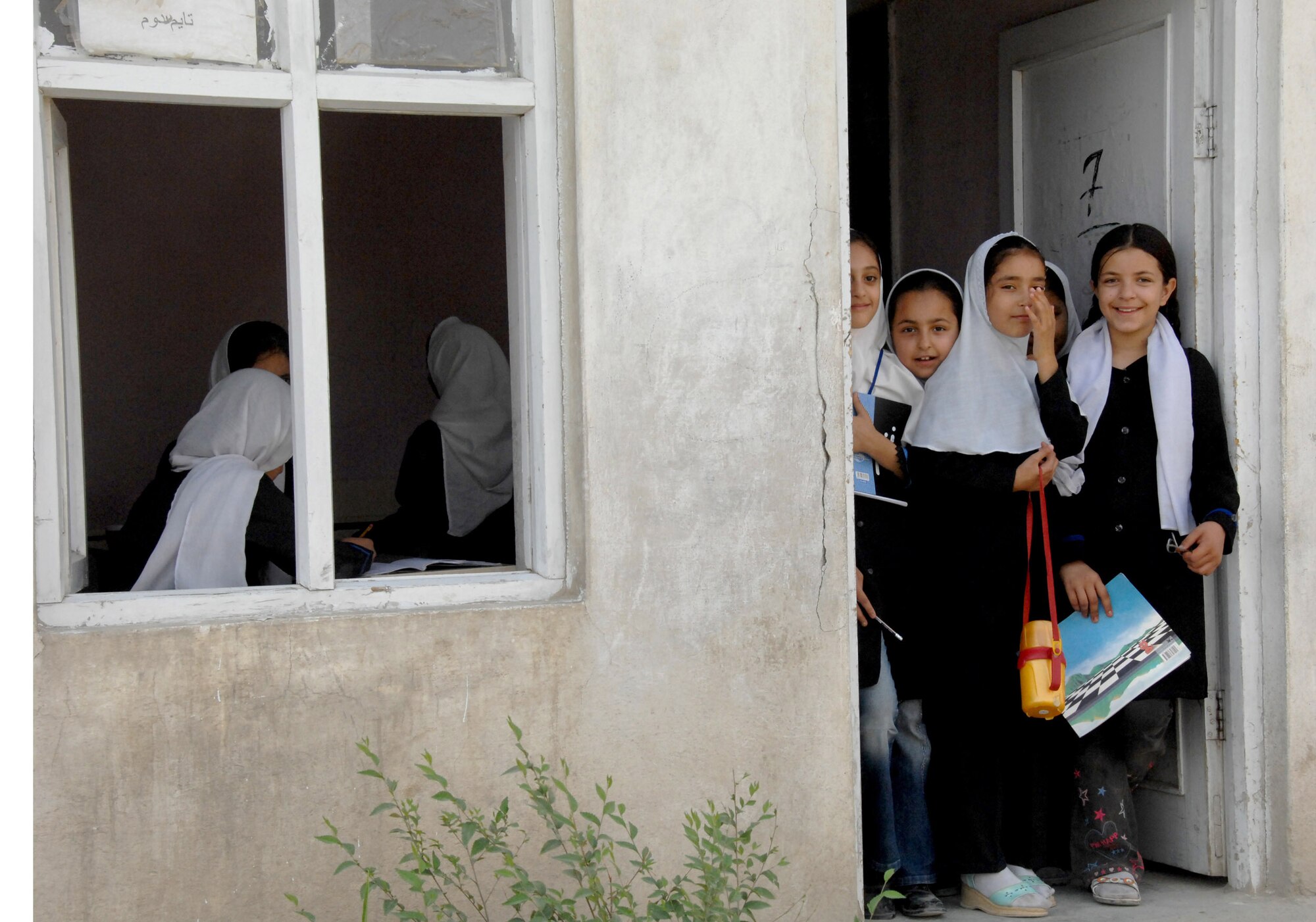 Female Afghan students cluster around the door of their Kabul school.  International Security Assistance Force troops visited the school Aug. 5, 2007, to deliver school supplies. (ISAF photo by Master Sgt. Russell P. Petcoff)