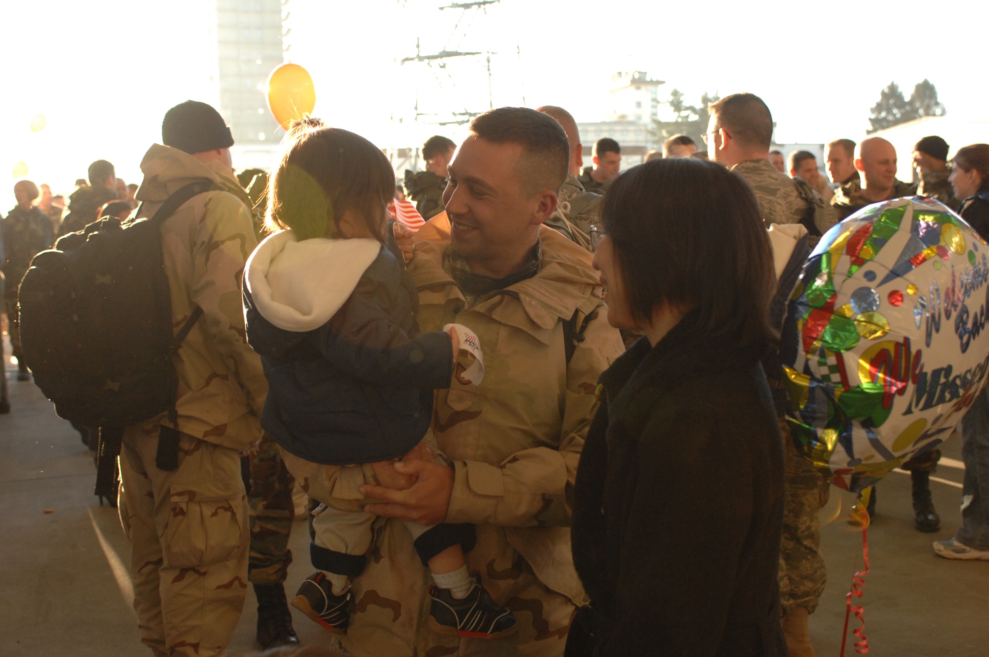 SPANGDAHLEM AIR BASE, Germany -- Staff Sgt. David Schwanke, 52nd Equipment Maintenance Squadron, holds his son Lucas with wife Mari upon his return from a deployment in support of Operation Iraqi Freedom, Feb. 8, 2008. (U.S. Air Force photo/Senior Airman Kristin Ruleau) 