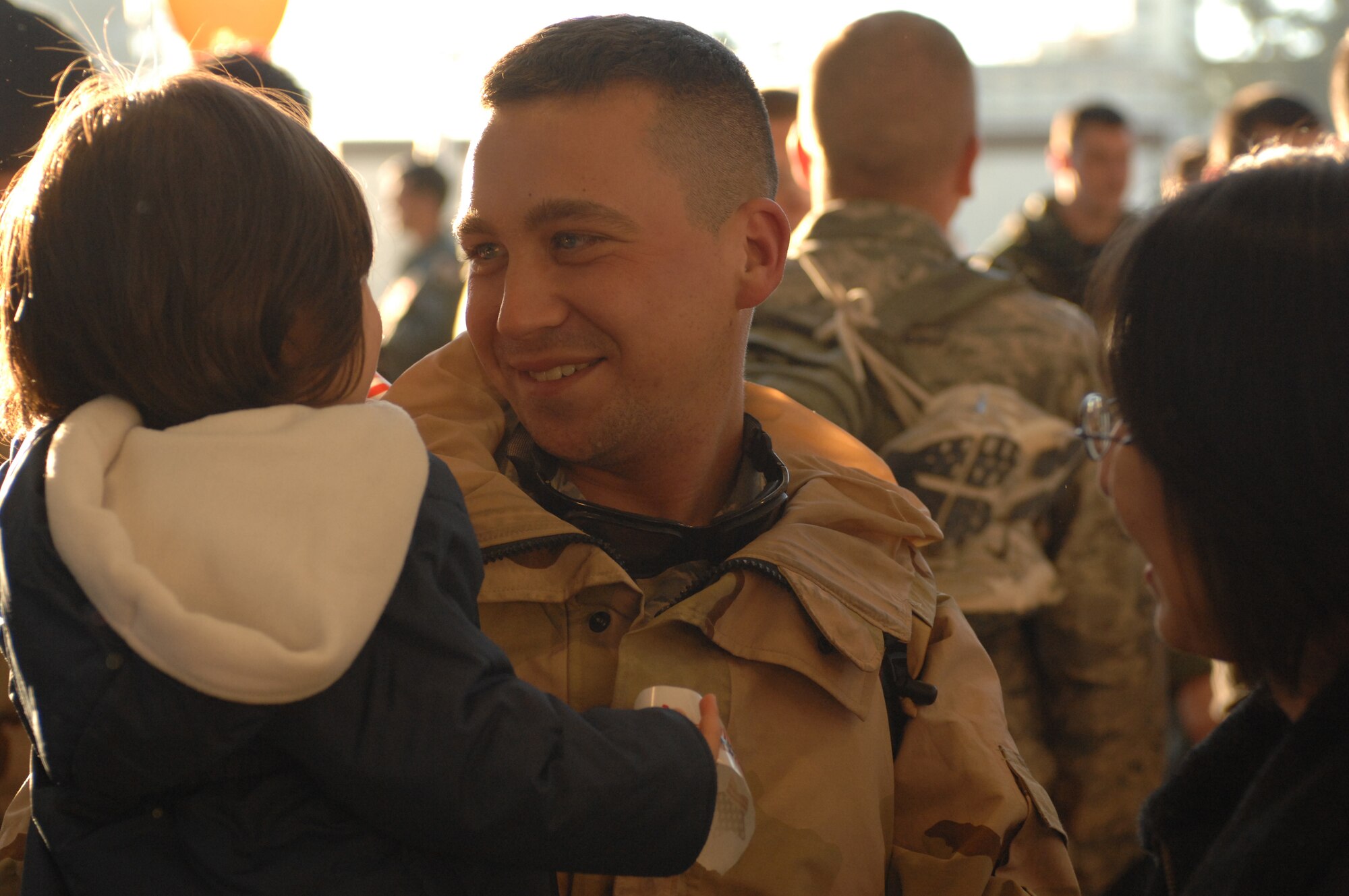 SPANGDAHLEM AIR BASE, Germany -- Staff Sgt. David Schwanke, 52nd Equipment Maintenance Squadron, holds his son Lucas with wife Mari upon his return from a deployment in support of Operation Iraqi Freedom, Feb. 8, 2008. (U.S. Air Force photo/Senior Airman Kristin Ruleau) 