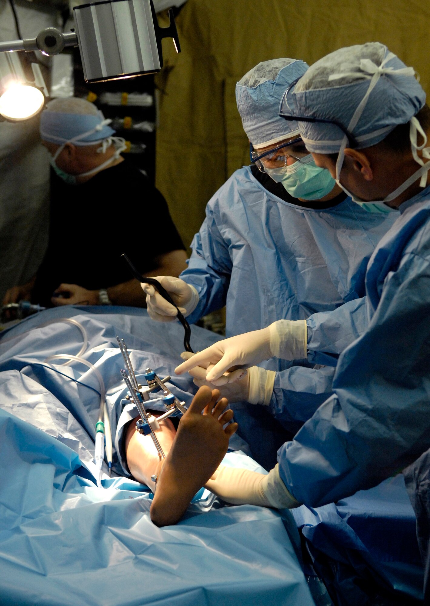 Lt. Col. Greg Schumacher explains how to apply an external fixator on a patient to Senior Airman Wallace Cleveland during Exercise Pacific Lifeline Feb. 5 at Kona International Airport, Hawaii. Colonel Schumacher, a staff orthopedic surgeon, and Airman Cleveland, a surgical technician, are from the 3rd Medical Group from Elmendorf Air Force Base, Alaska. Pacific Lifeline is a total force exercise staging from three locations within the Hawaiian Islands. It provides approximately 900 Department of Defense members a test environment to rapidly deploy and provide time-critical services in the wake of a simulated natural disaster. (U.S. Air Force photo/Tech. Sgt. Shane A. Cuomo) 
