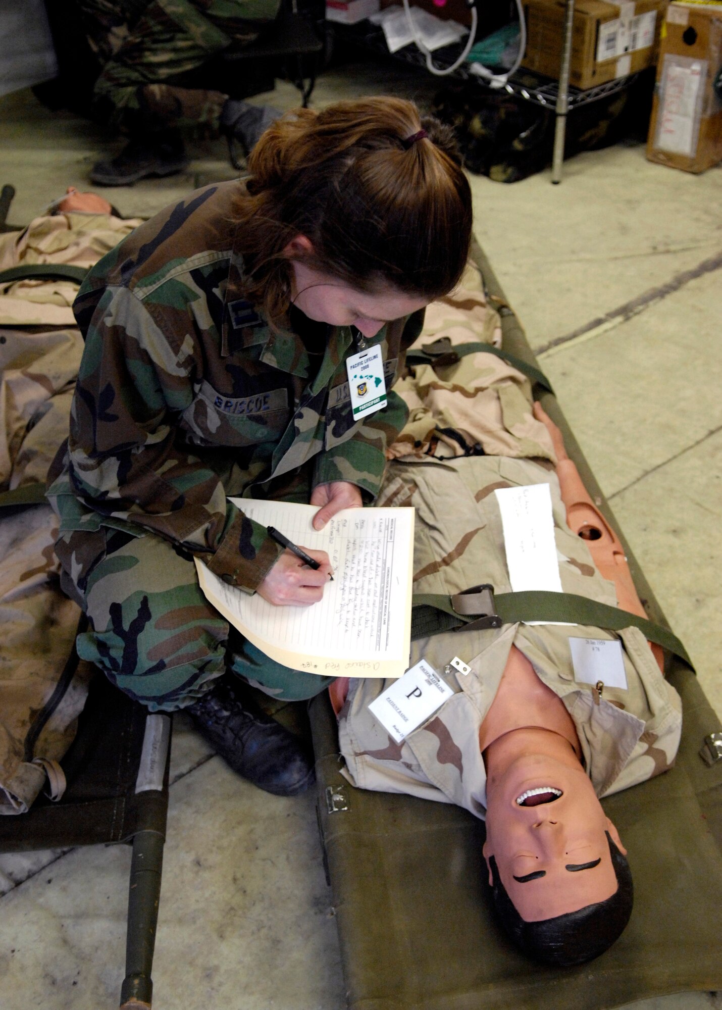 Capt. Rebekah Briscoe talks with a simulated patient during Exercise Pacific Lifeline Feb. 5 at Kona International Airport, Hawaii. Captain Briscoe is a family practice physician with the 3rd Medical Group at Elmendorf Air Force Base, Alaska. Pacific Lifeline is a total force exercise staging from three locations within the Hawaiian Islands. It provides approximately 900 Department of Defense members a test environment to rapidly deploy and provide time-critical services in the wake of a simulated natural disaster. (U.S. Air Force photo/Tech. Sgt. Shane A. Cuomo)