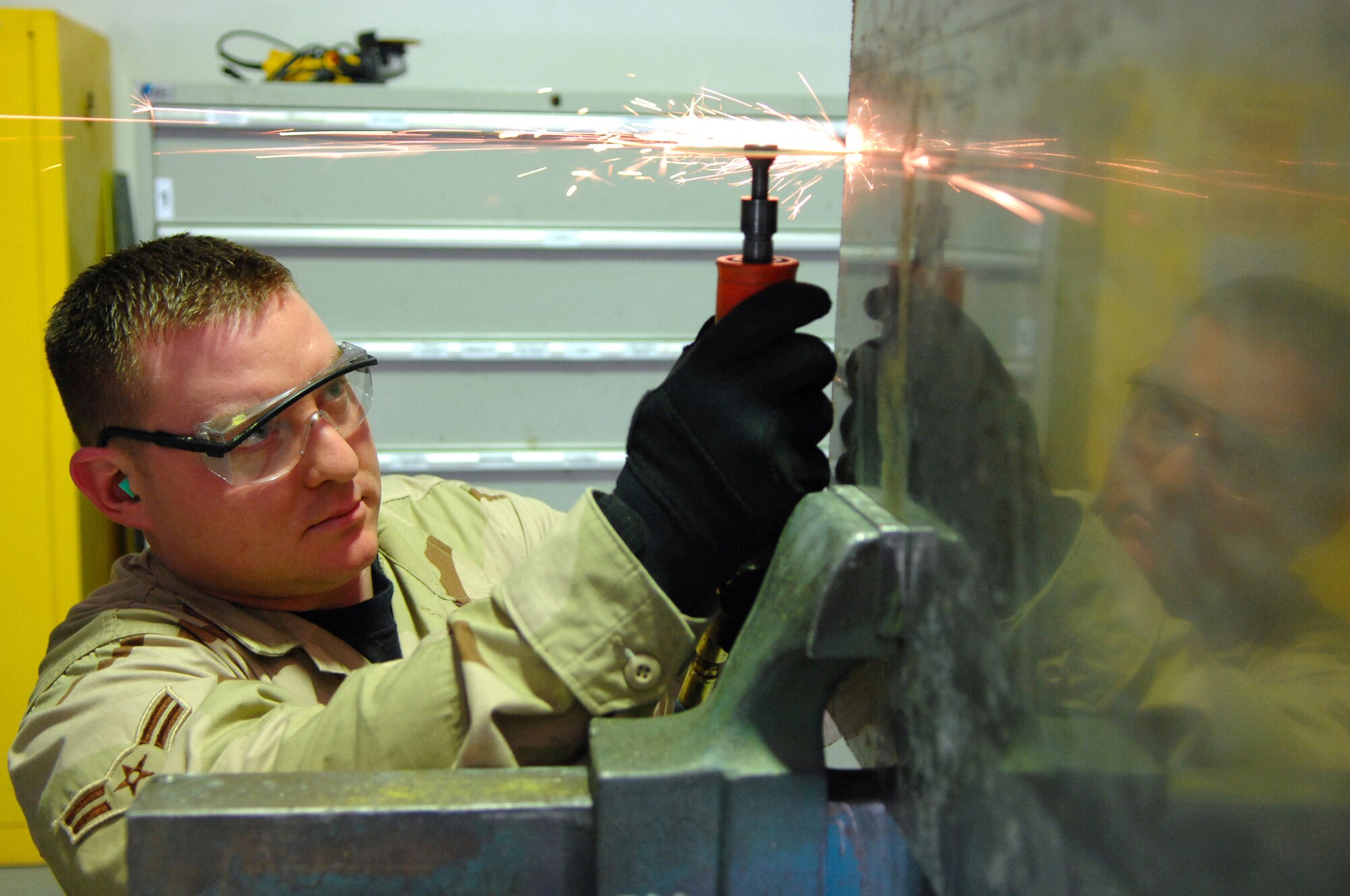 BALAD AIR BASE, Iraq -- Airman 1st Class Jason Kahawaiolaa, 332nd Expeditionary Maintenance Squadron aircraft structural maintainer, uses a pneumatic grinder to fabricate a metal repair plate for an F-16 Fighting Falcon here, Feb. 6. Airmen in the structures shop are responsible for body maintenance on all aircraft based here and any transient aircraft. Airman Kahawaiolaa is deployed from Spangdahlem Air Base, Germany. (U.S. Air Force photo/ Senior Airman Julianne Showalter)