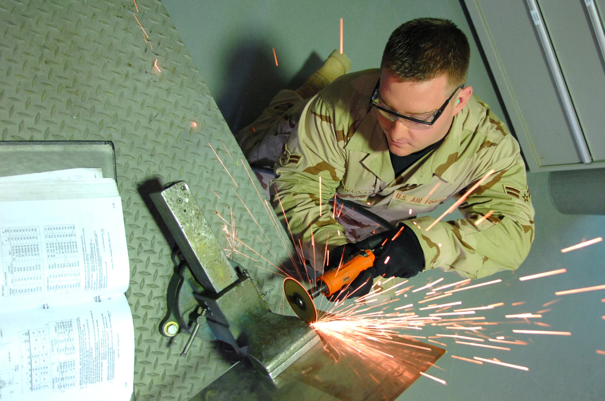 BALAD AIR BASE, Iraq -- Airman 1st Class Jason Kahawaiolaa, 332nd Expeditionary Maintenance Squadron aircraft structural maintainer, uses a pneumatic grinder to fabricate a metal repair plate for an F-16 Fighting Falcon here, Feb. 6. Structural maintainers can repair fighters and return them operational status in less than a day. Airman Kahawaiolaa is deployed from Spangdahlem Air Base, Germany. (U.S. Air Force photo/ Senior Airman Julianne Showalter)
